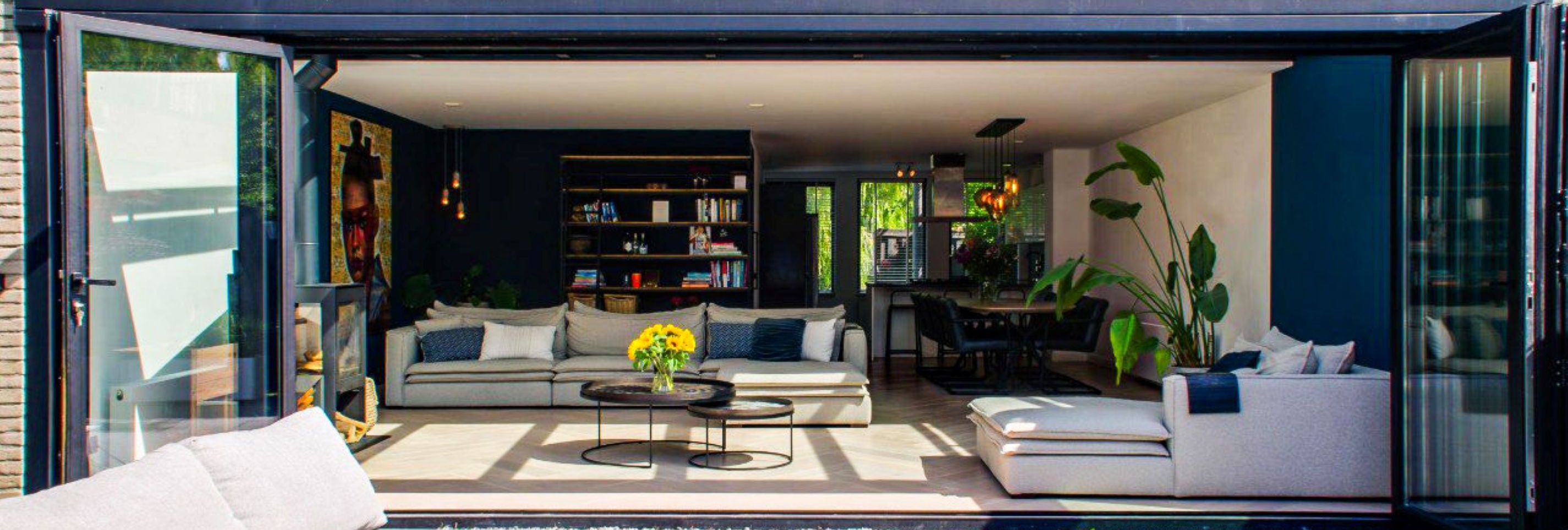 Ruime serre met glazen dak en brede opening naar de tuin voor een open woonbeleving