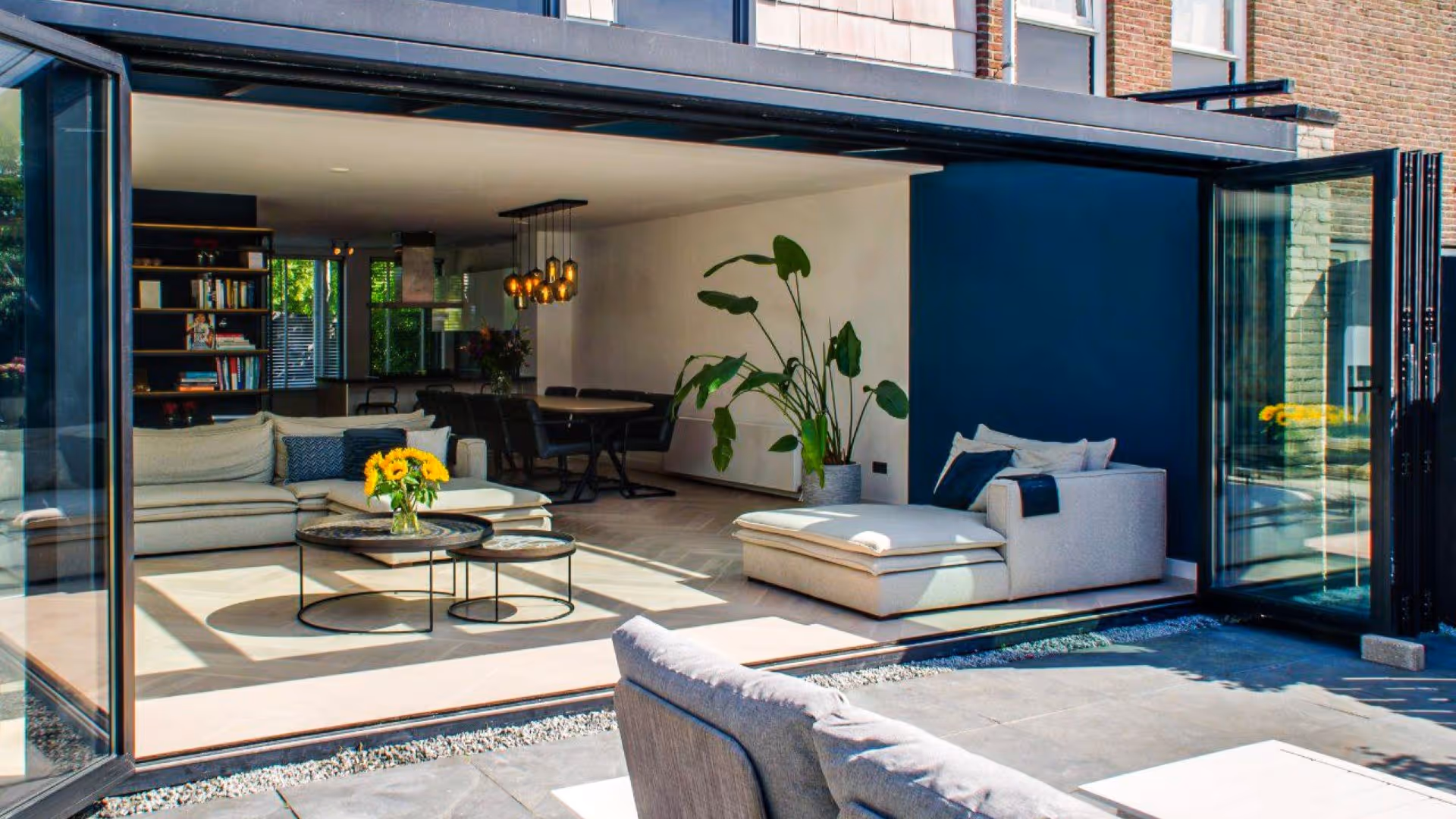Moderne aluminium serre met glazen dak en grote schuifpuien voor maximale lichtinval