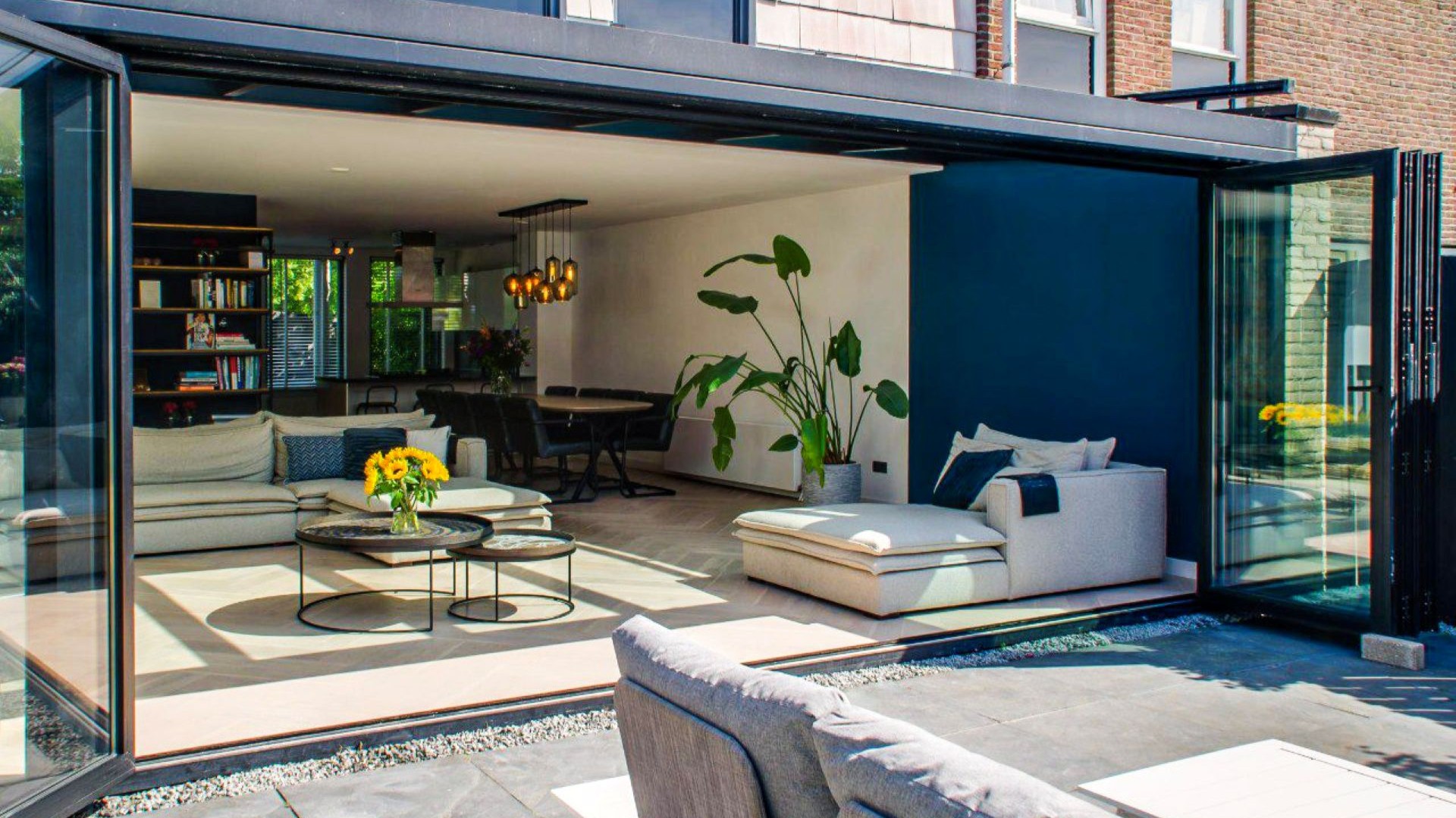 Moderne aluminium serre met glazen dak en grote schuifpuien voor maximale lichtinval