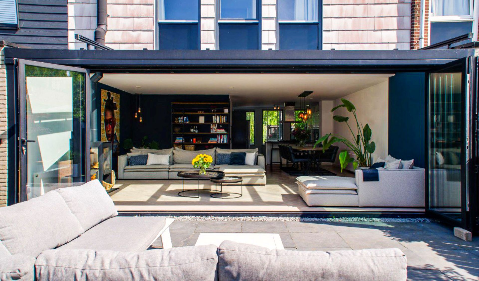 Moderne serre met open schuifpuien en directe verbinding tussen woonkamer en tuin