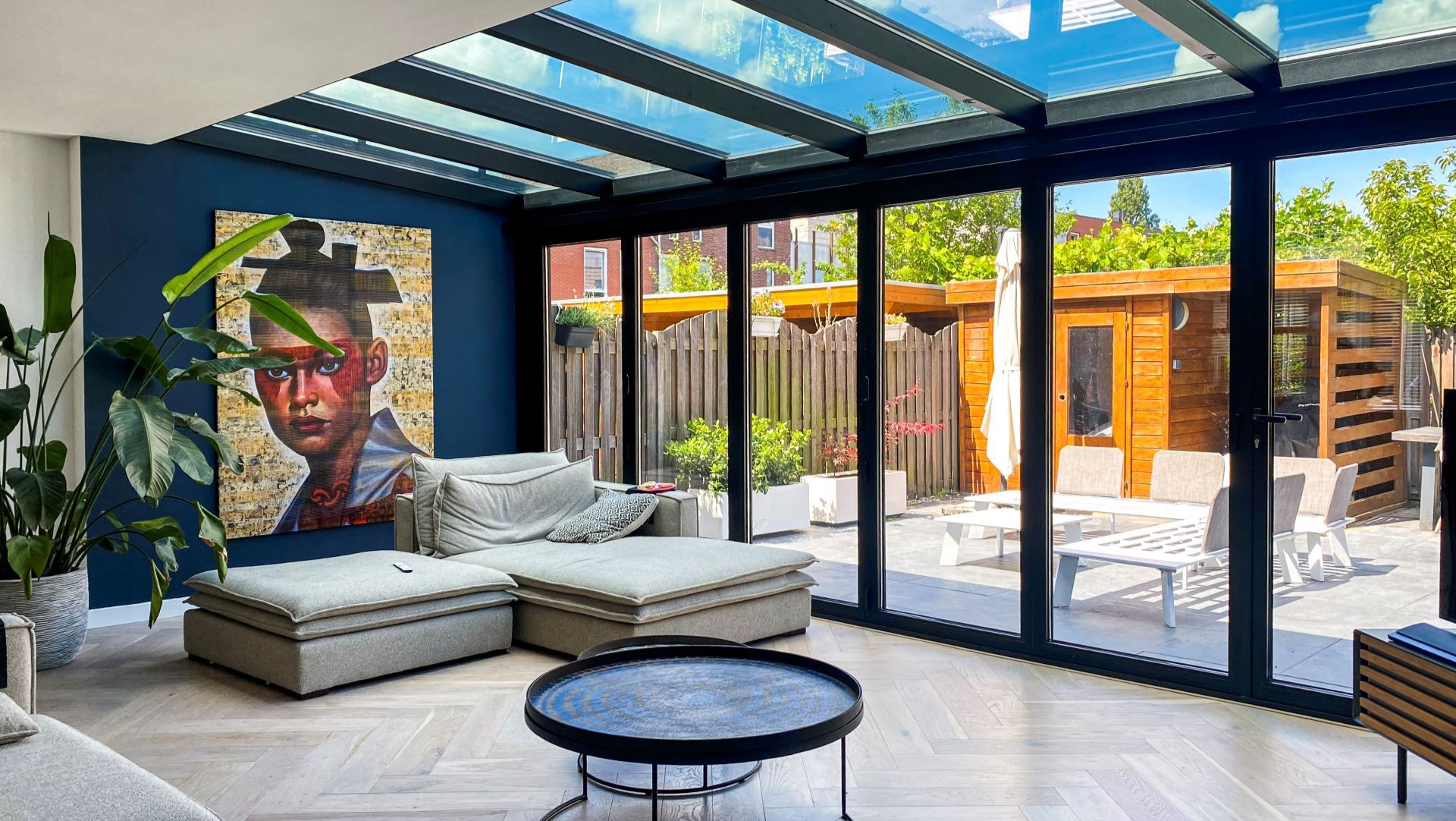 Moderne serre met glazen wanden en schuifpuien voor een lichte en open leefruimte