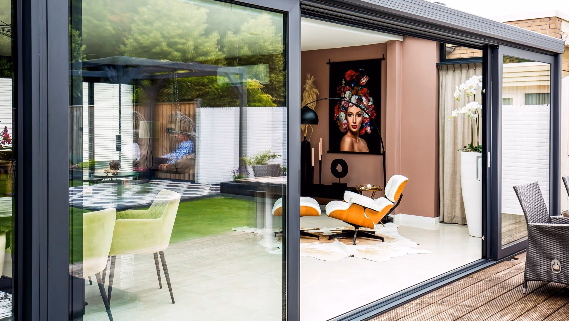 Buitenaanzicht moderne serre met schuifpui en terras
