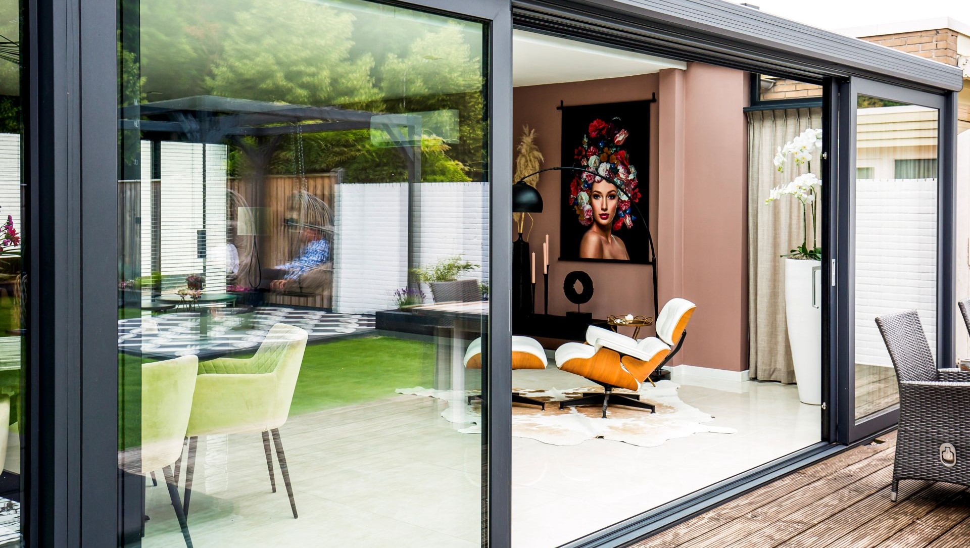 Buitenaanzicht moderne serre met schuifpui en terras