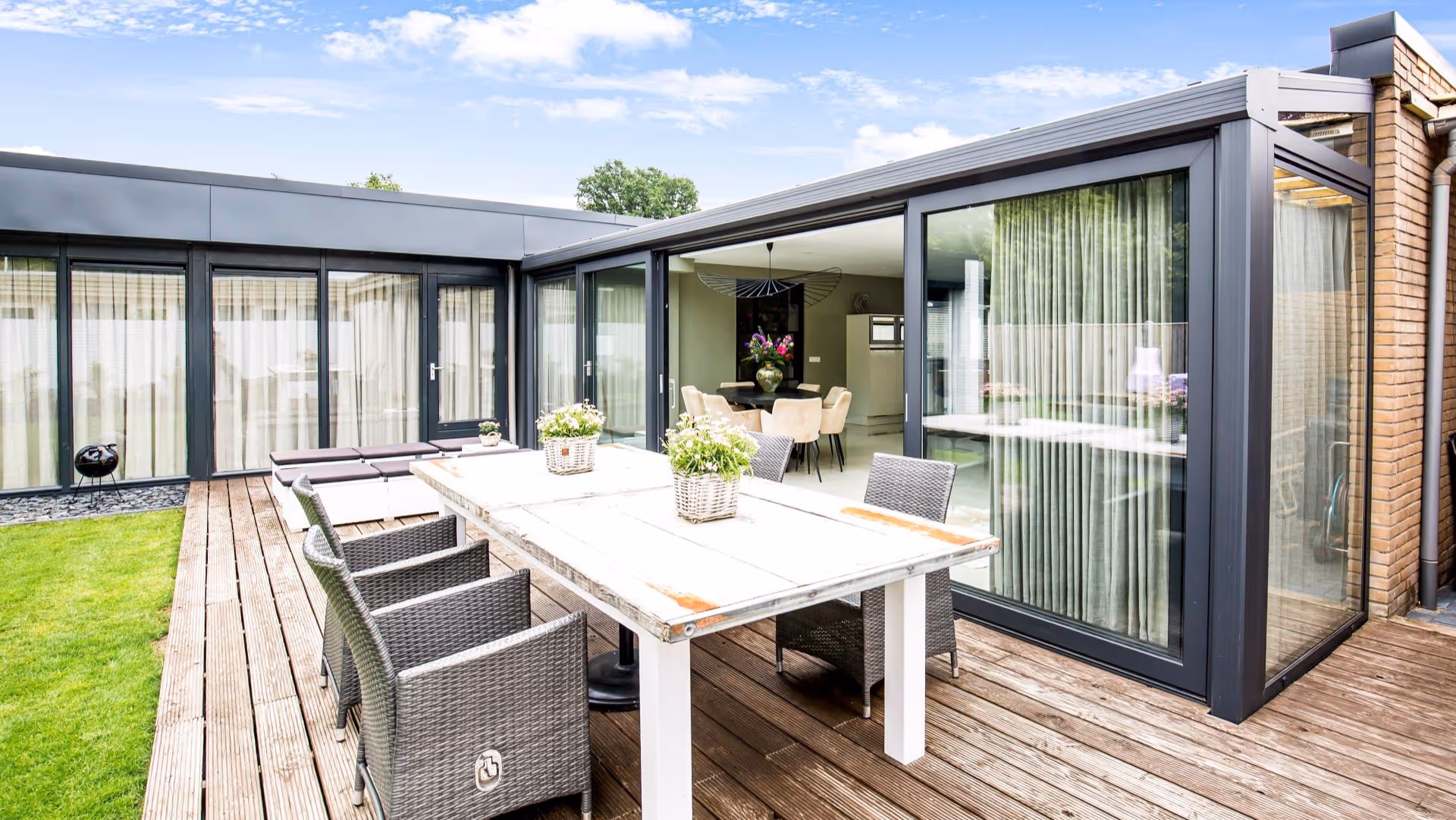 Terras met uitzicht op serre met glazen schuifdeuren