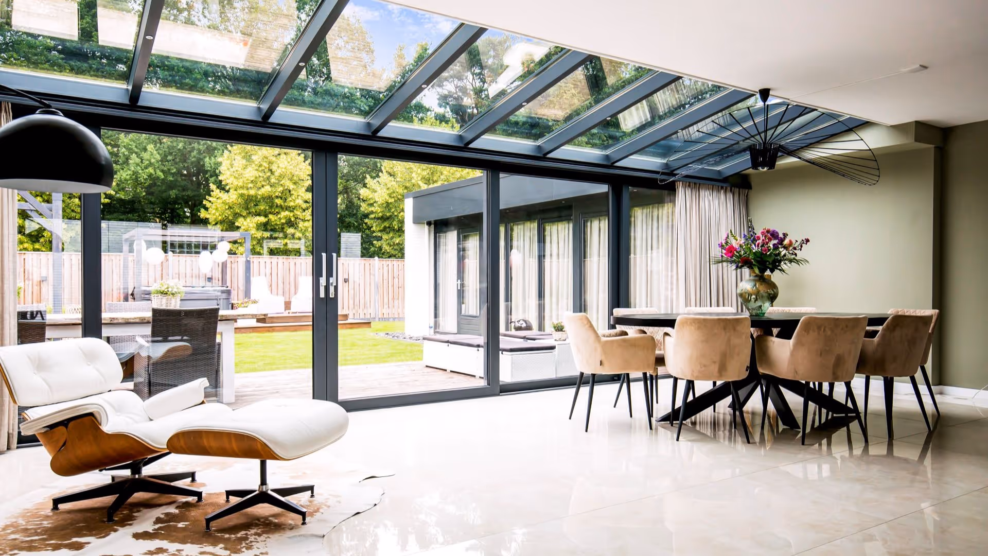 Ruime serre met design stoel en volledig glazen pui