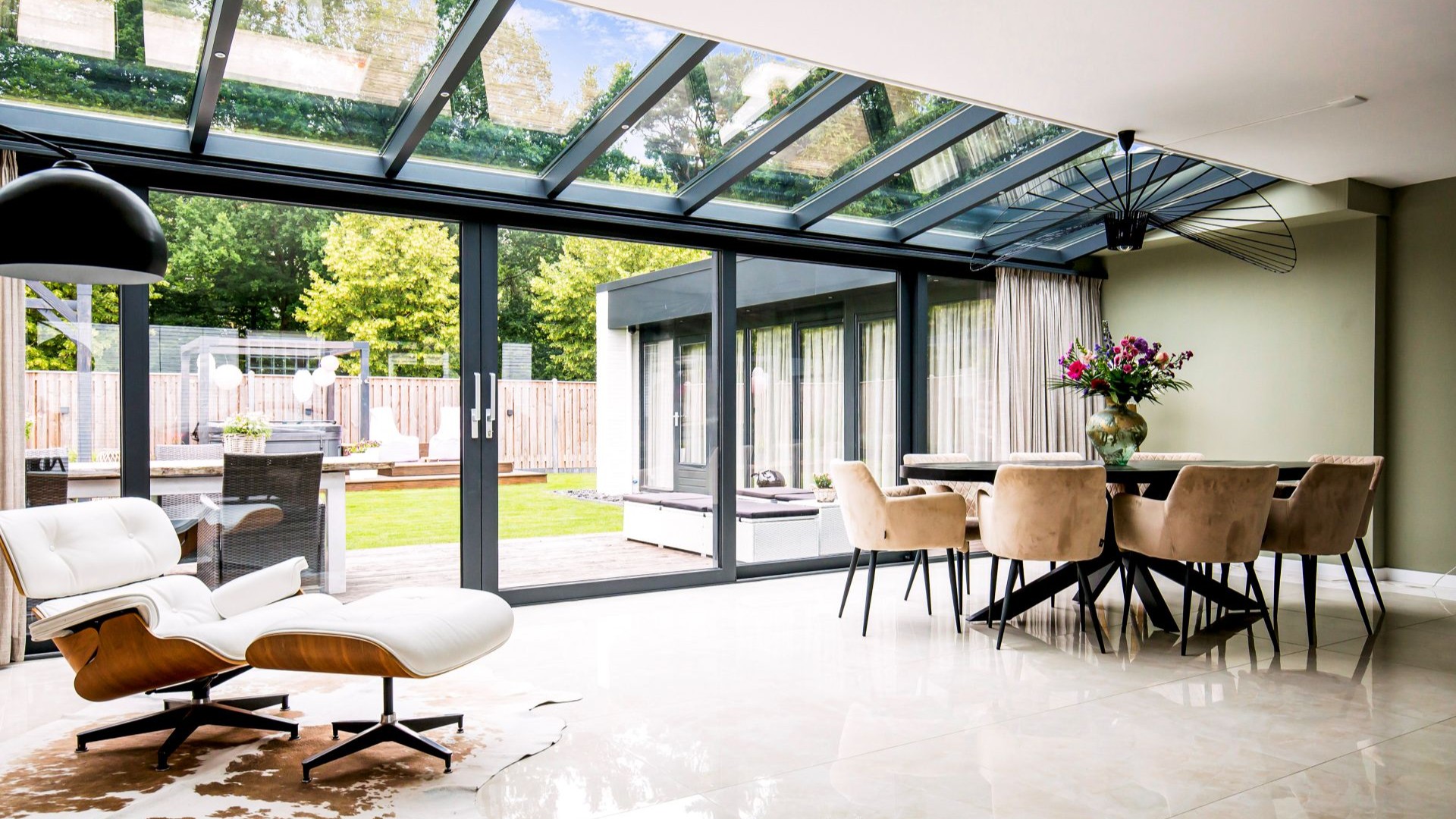 Ruime serre met design stoel en volledig glazen pui