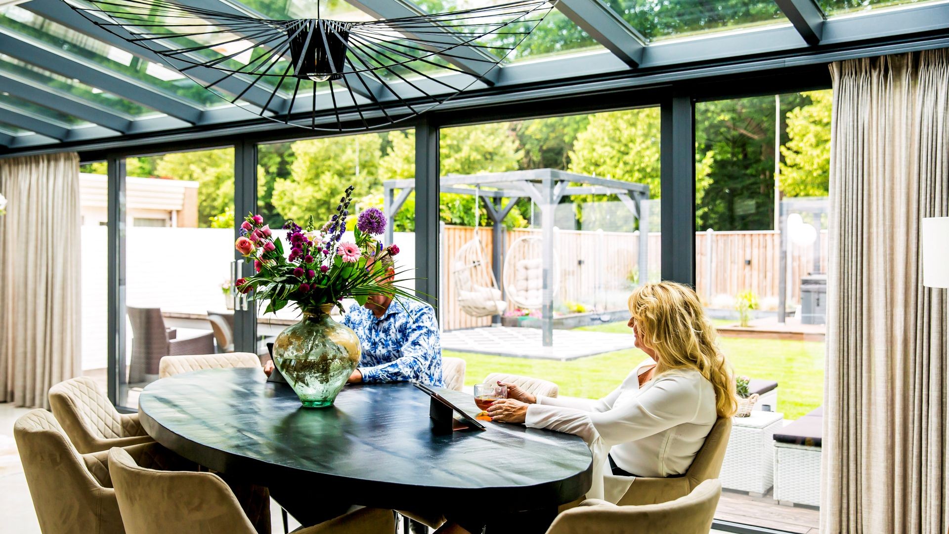 Ronde eettafel in moderne serre met glazen dakconstructie