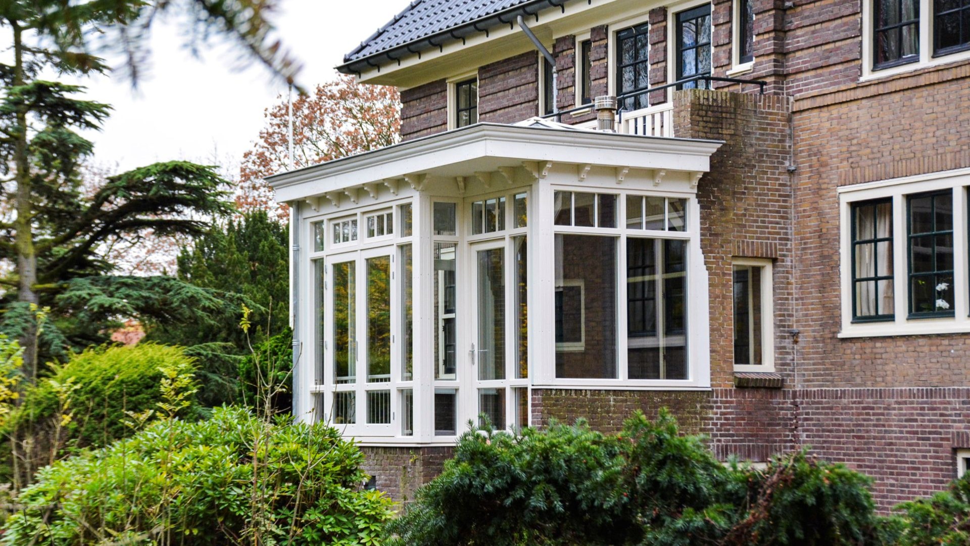 Luxe serre met openslaande deuren en veel glas, geplaatst aan een karakteristieke woning in Heemstede