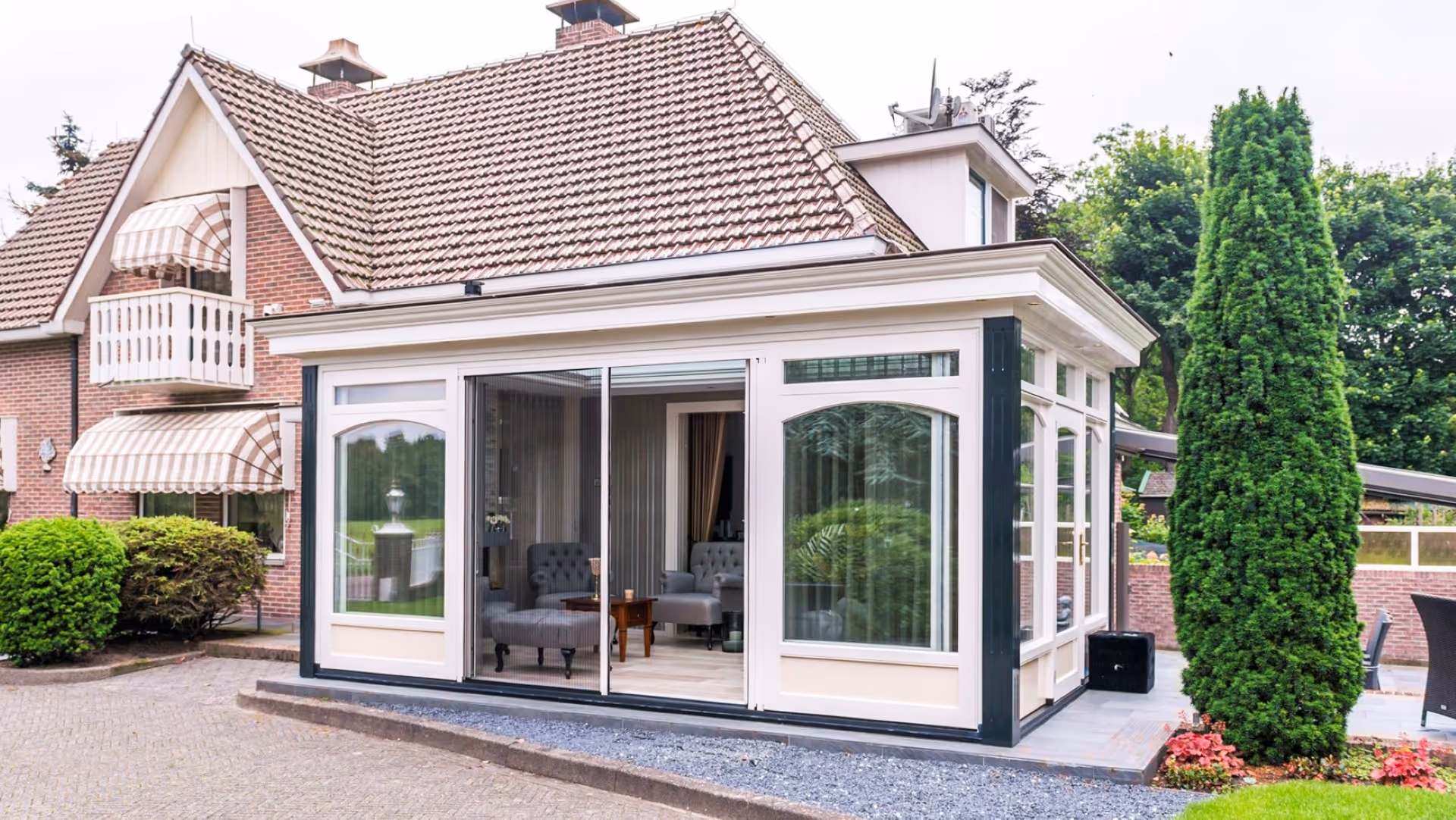 Klassieke serre aanbouw met schuifpui en stijlvolle kozijnen aan vrijstaande woning