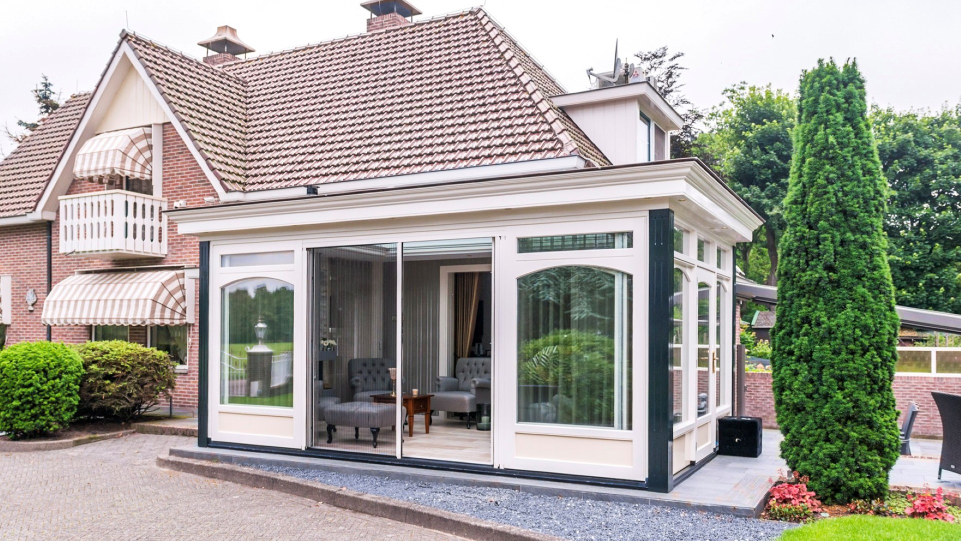 Klassieke serre aanbouw met schuifpui en stijlvolle kozijnen aan vrijstaande woning