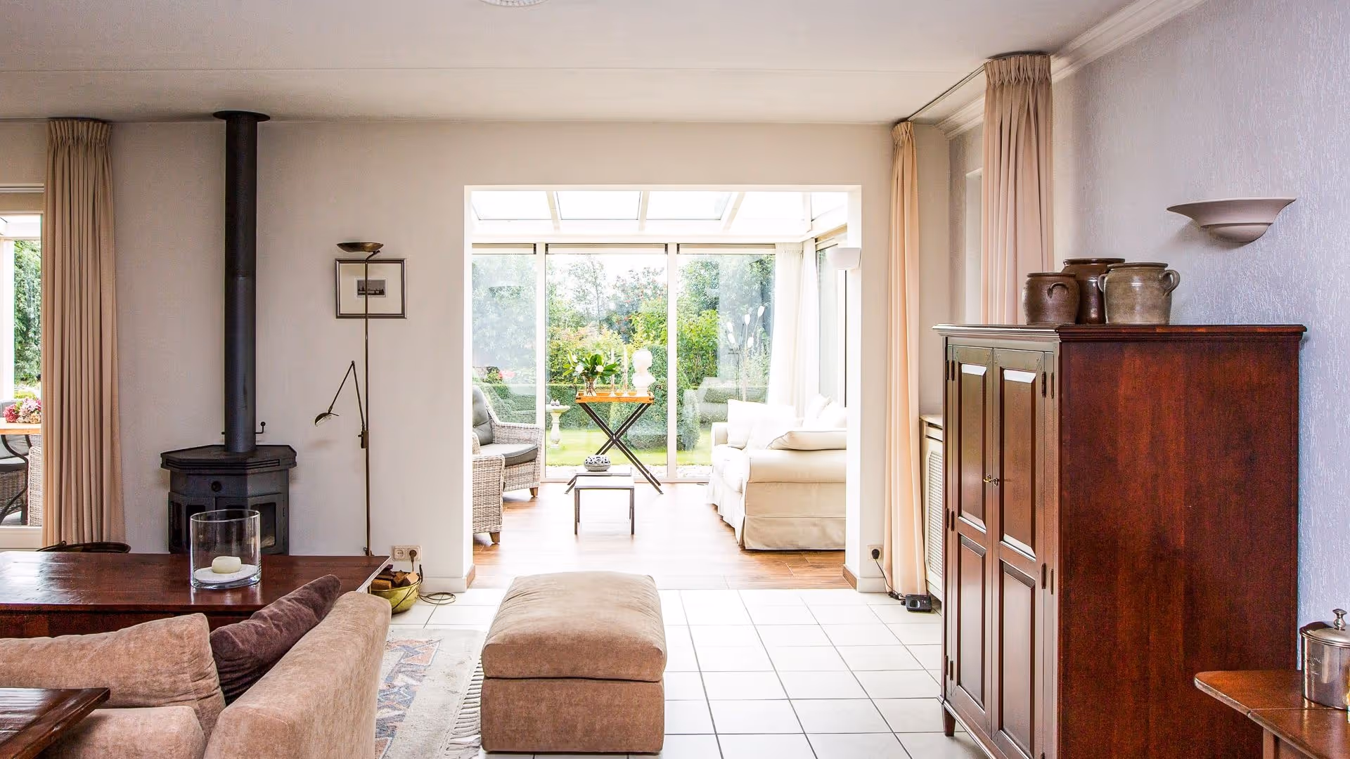 Doorkijk vanuit de woning naar de lichte tuinkamer met uitzicht op de tuin