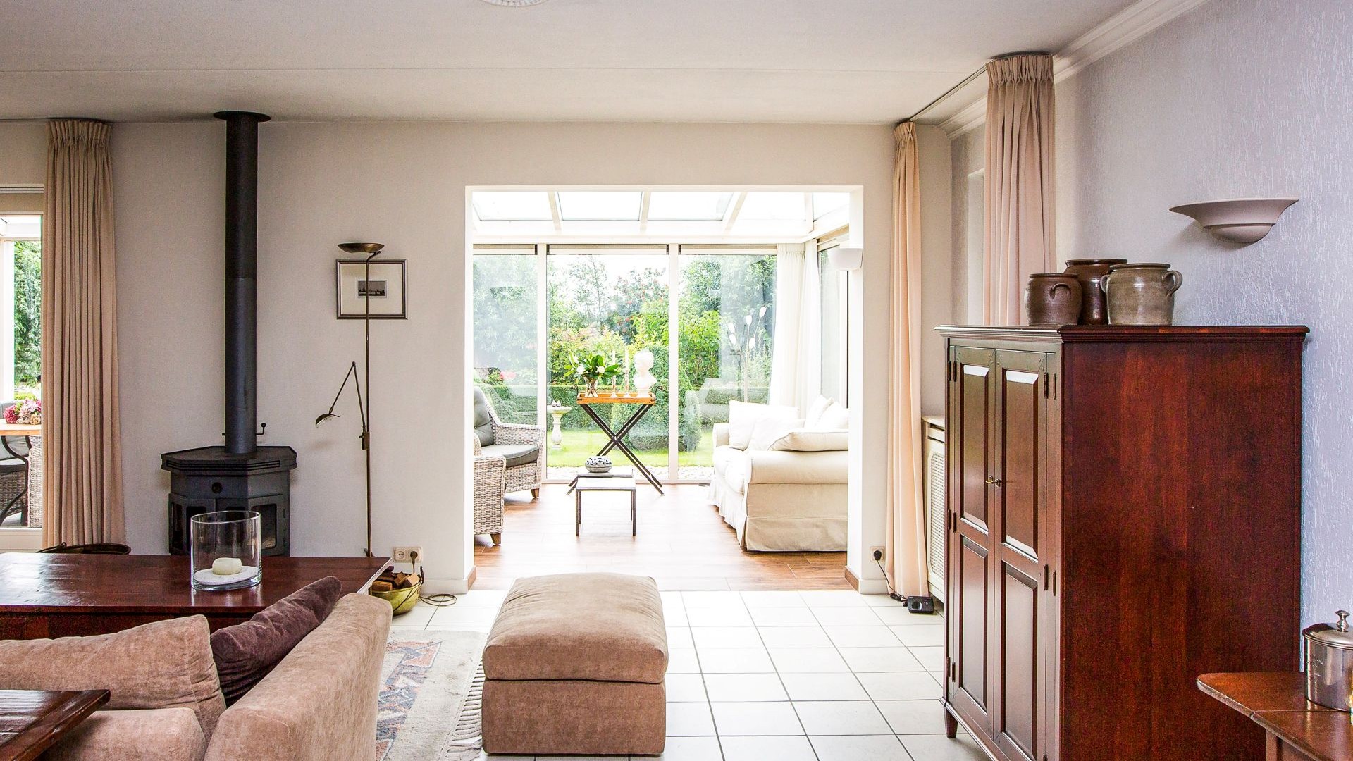 Doorkijk vanuit de woning naar de lichte tuinkamer met uitzicht op de tuin