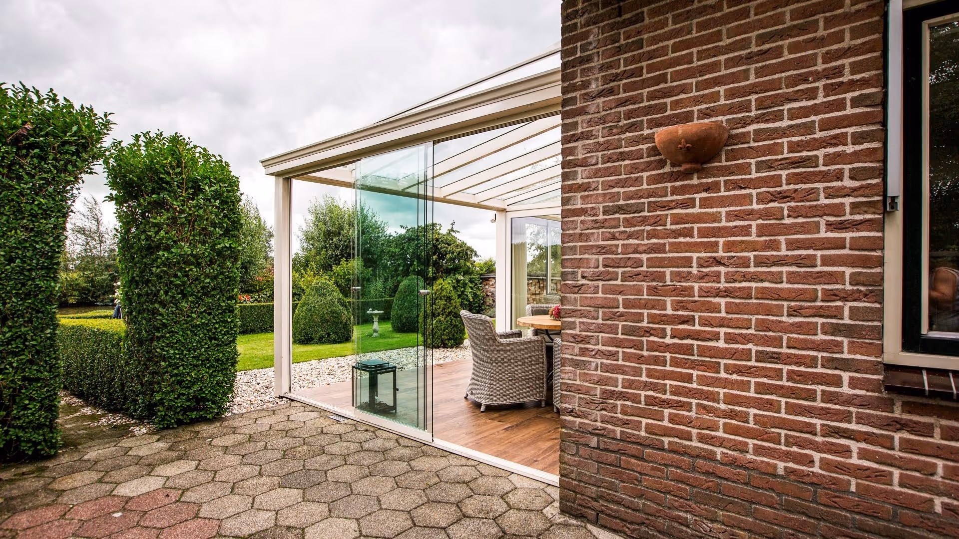 Tuinkamer met glazen schuifwanden en sfeervol ingericht terrasgedeelte