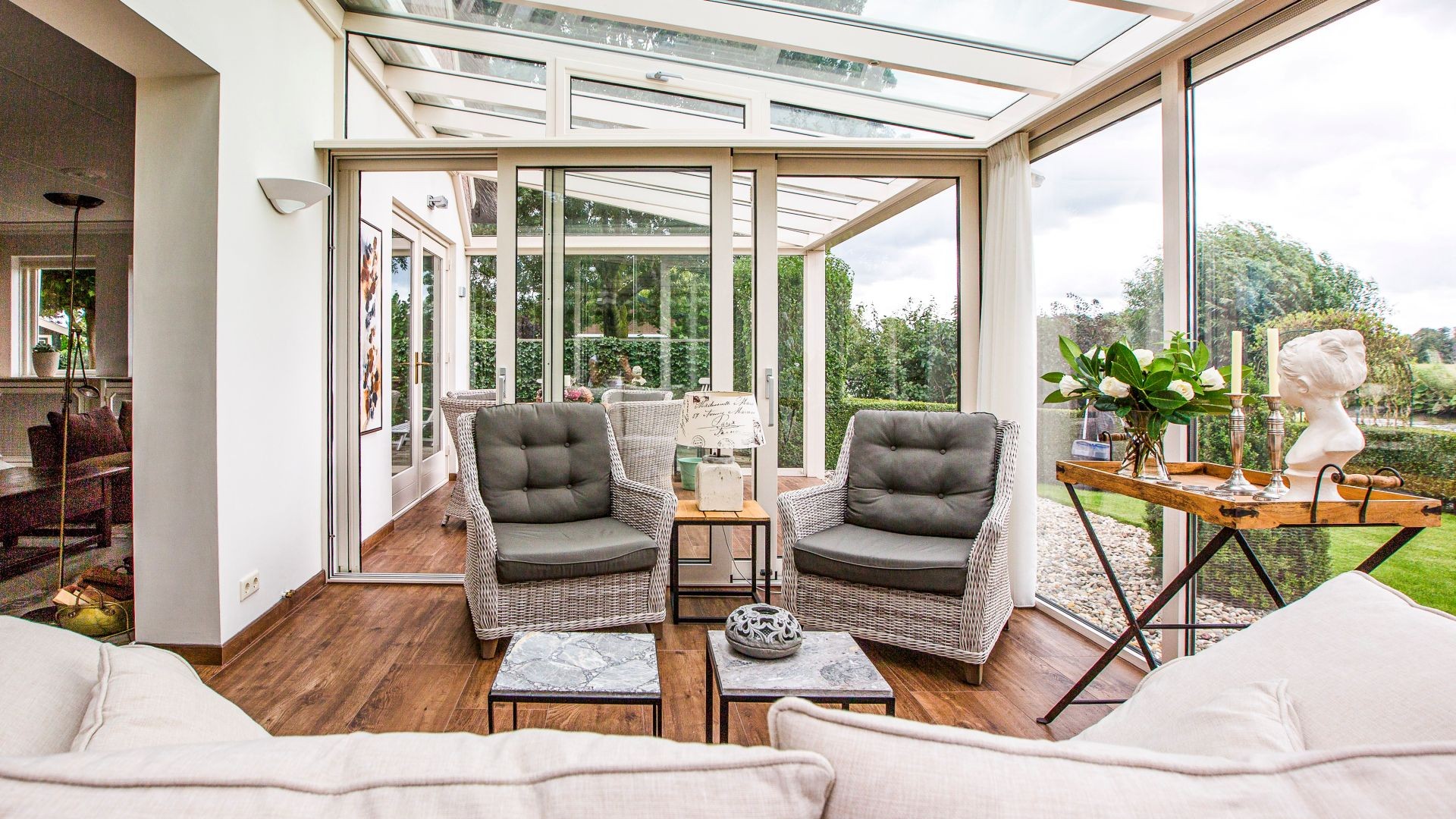 Tuinkamer met glazen schuifwanden en gedeeltelijk overdekt terras met zitgedeelte
