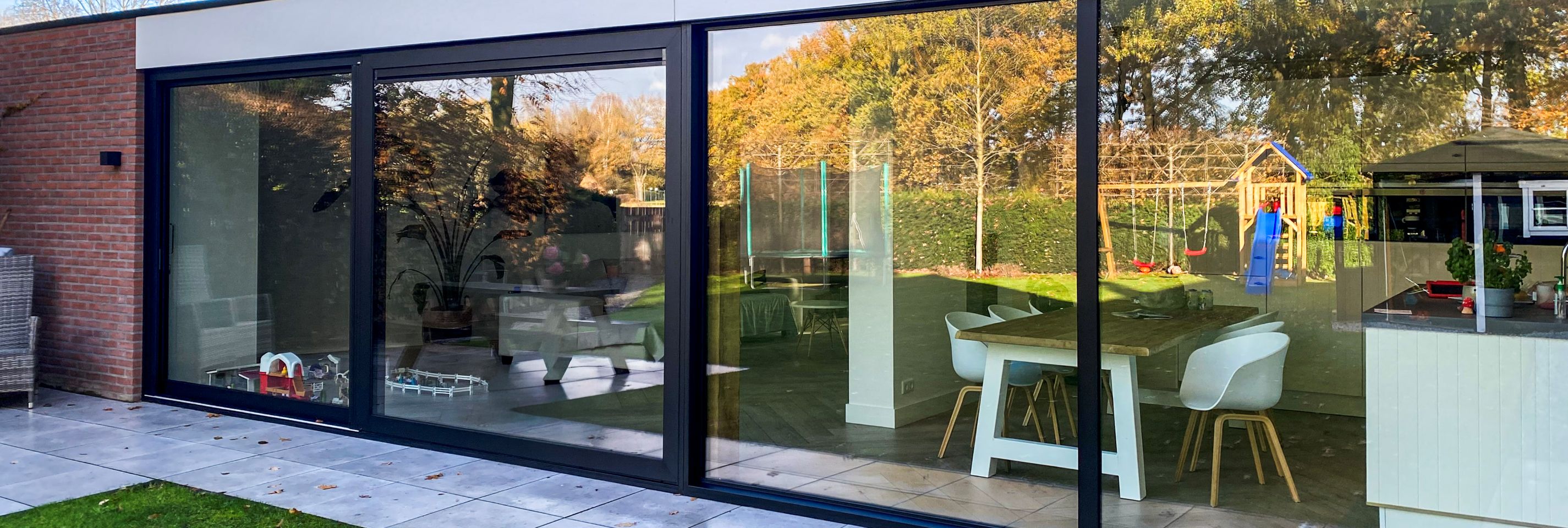 Moderne woning met strakke schuifpuien en grote glasoppervlakken die binnen en buiten verbinden