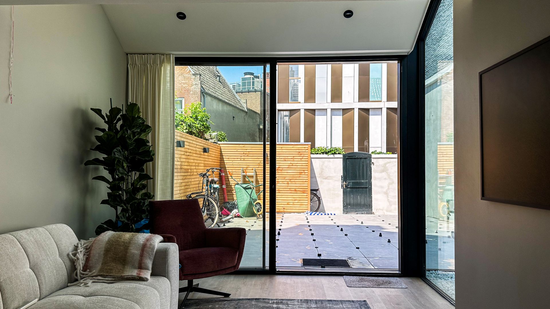 Interieur met grote zwarte schuifpui die zorgt voor een open verbinding met de buitenruimte