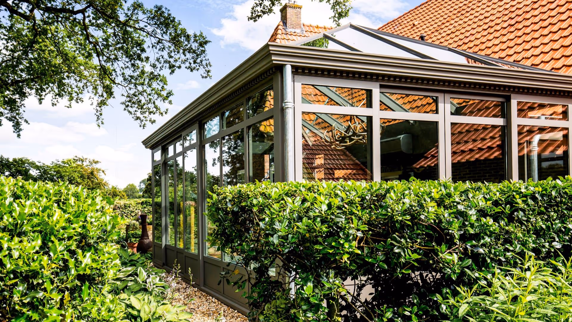 Overzicht van woning met serre en tuin