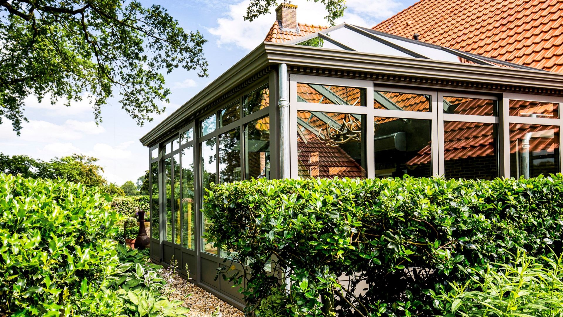 Overzicht van woning met serre en tuin