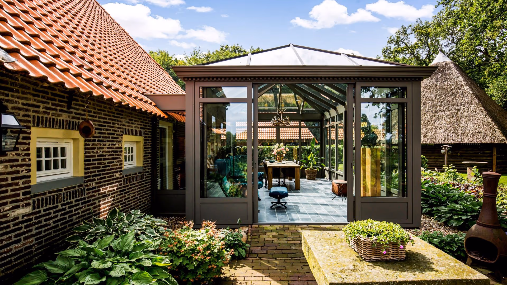 Tuinbeeld met serre en landelijke woning