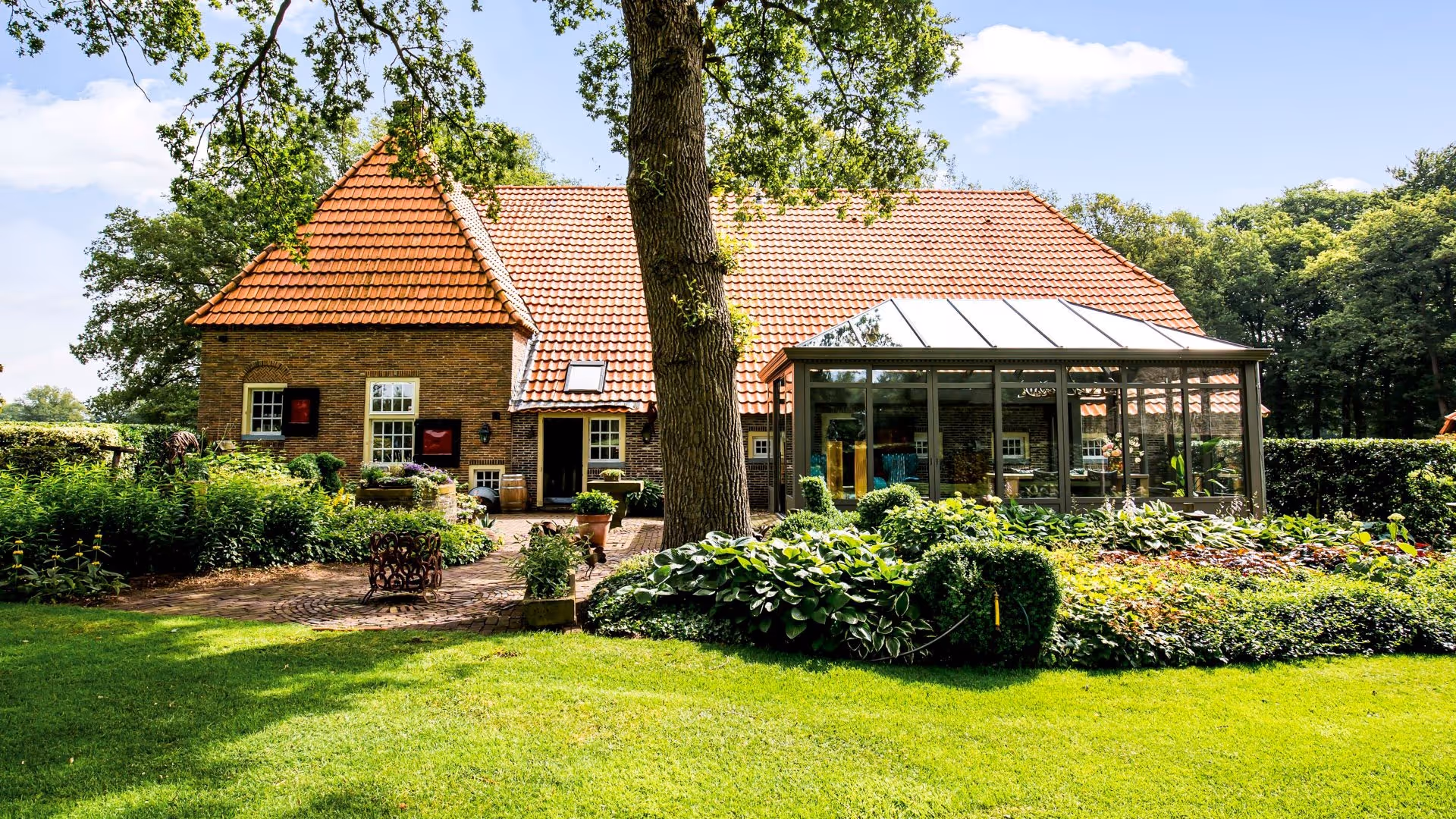 Tuinbeeld met zicht op serre en woning
