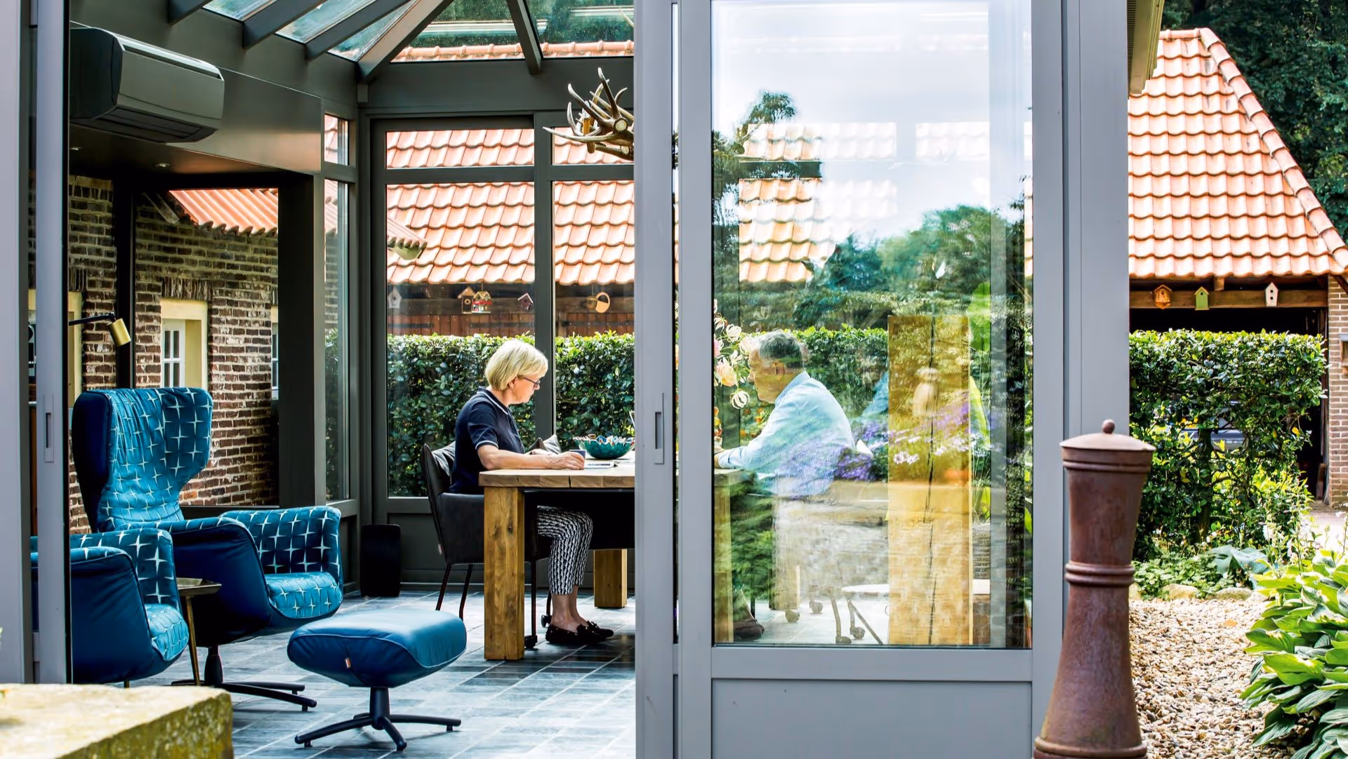 Buitenaanzicht van serre naast woning met tuin
