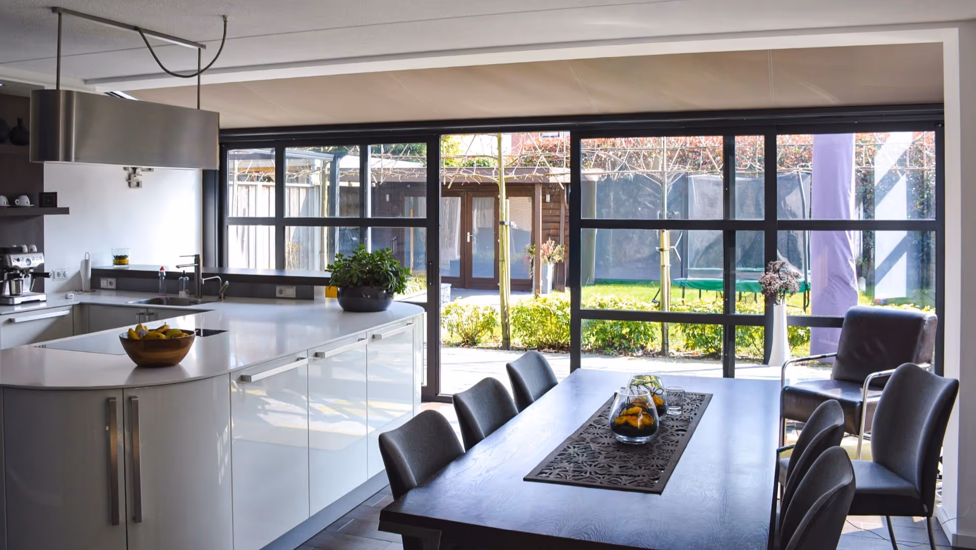 Moderne steellook serre met zwarte aluminium kozijnen aan open leefkeuken in Hengelo