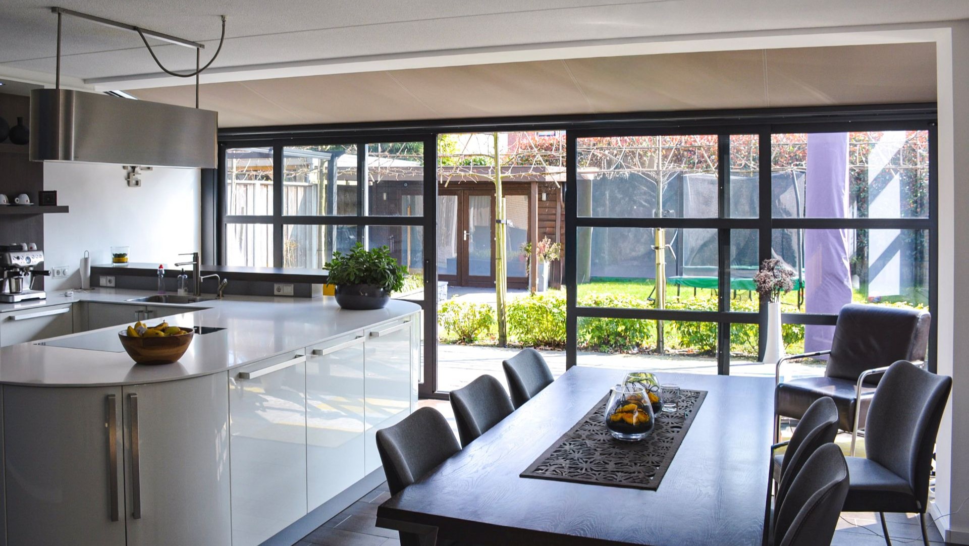 Moderne steellook serre met zwarte aluminium kozijnen aan open leefkeuken in Hengelo