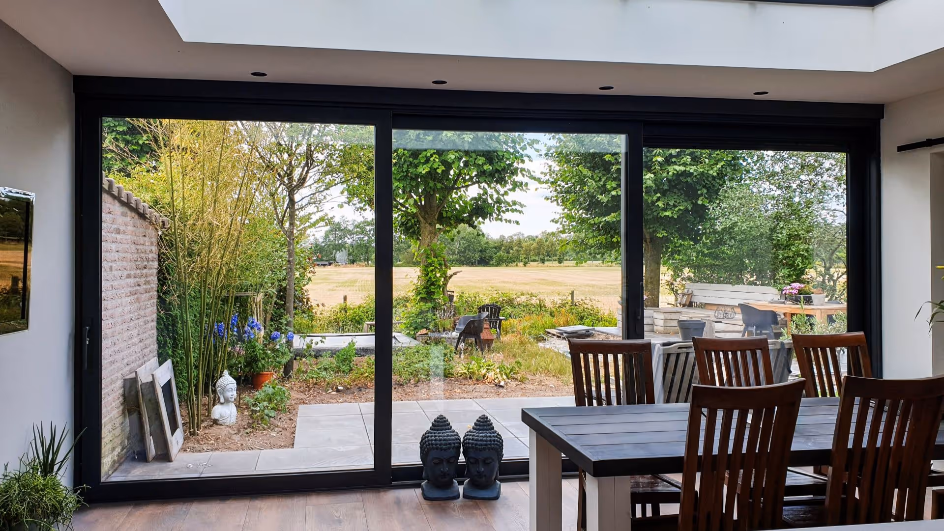 Moderne aluminium serre met grote schuifpui en vrij uitzicht op de tuin in Borculo