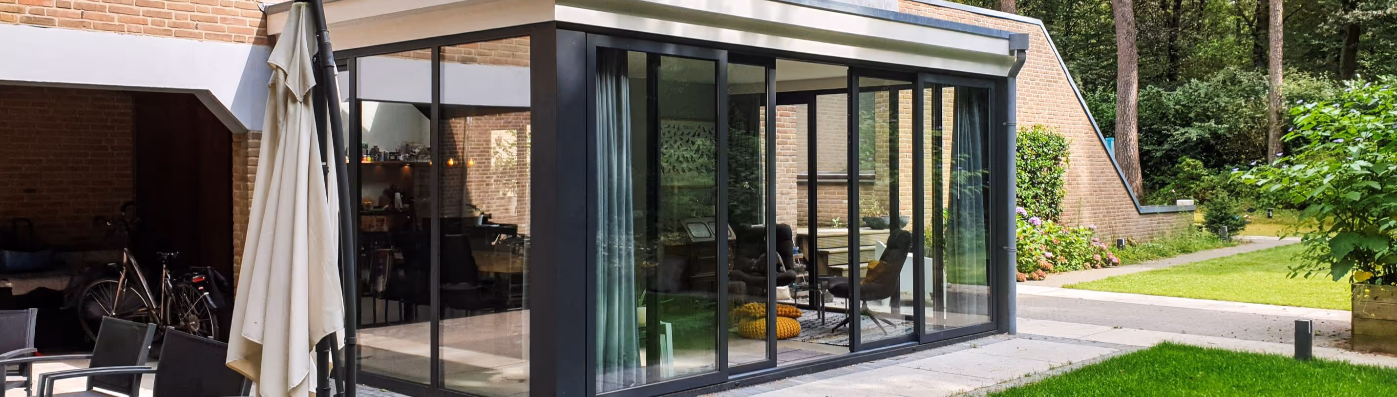 Serre uitbouw Doorwerth - Design serre met moderne aluminium schuifwanden en luxe woonuitbreiding aan villa