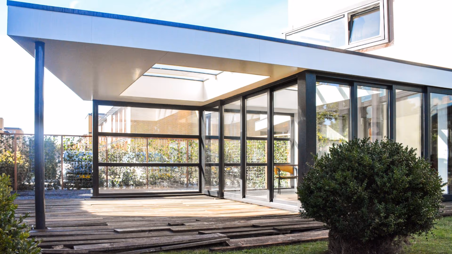 Moderne veranda serre combinatie met glazen schuifdeuren en stijlvolle aluminium constructie