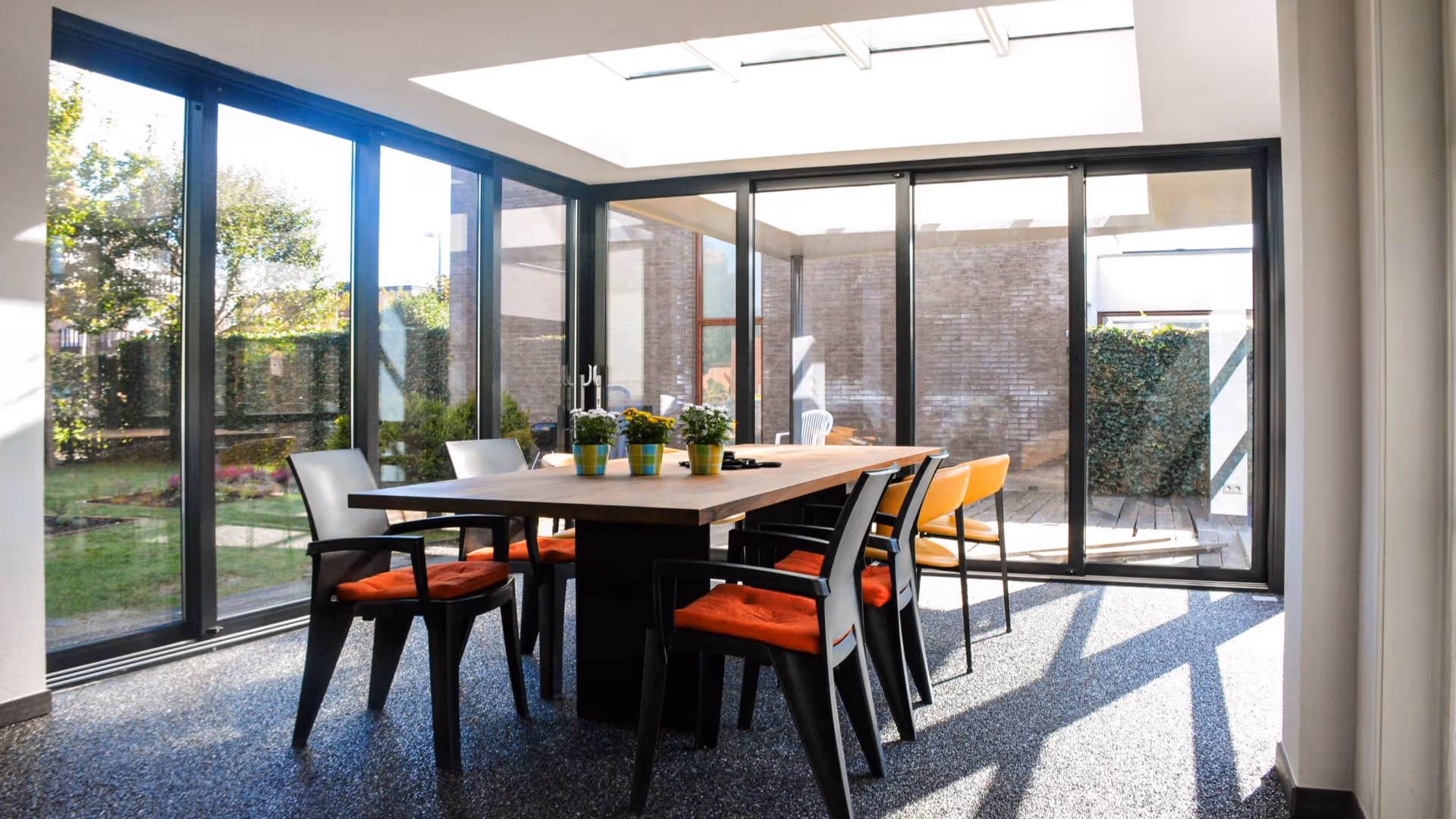 Luxe serre aanbouw met minimalistische aluminium kozijnen en stijlvolle eetkamer
