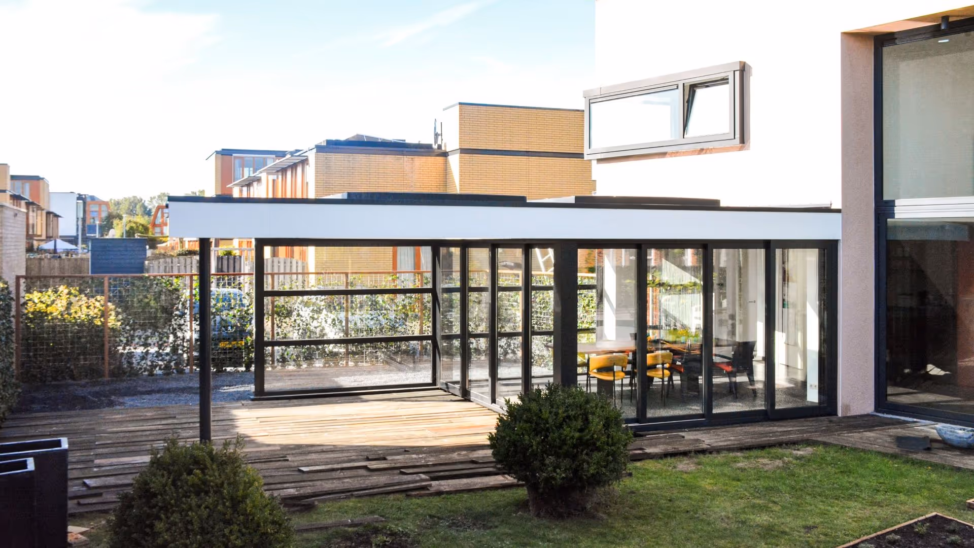 Hoogwaardige aluminium serre aanbouw met strak design en open verbinding naar de tuin