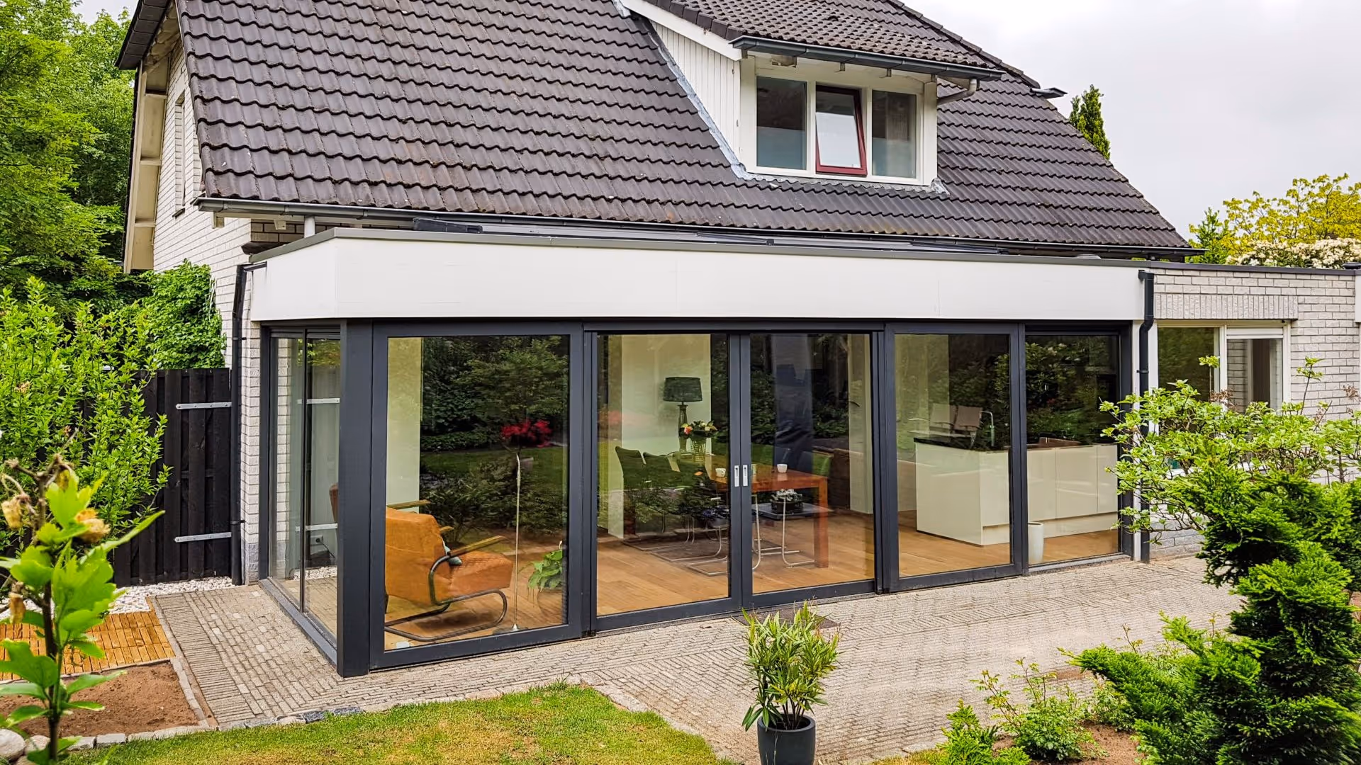 Luxe leefserre met zwarte aluminium kozijnen en open verbinding naar de tuin