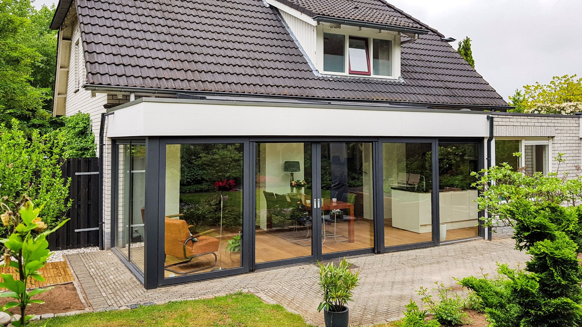 Luxe leefserre met zwarte aluminium kozijnen en open verbinding naar de tuin