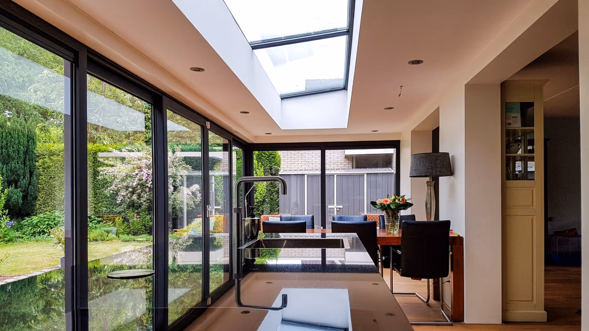 Design serre met grote glaspartijen, moderne keuken en stijlvolle eetkamer