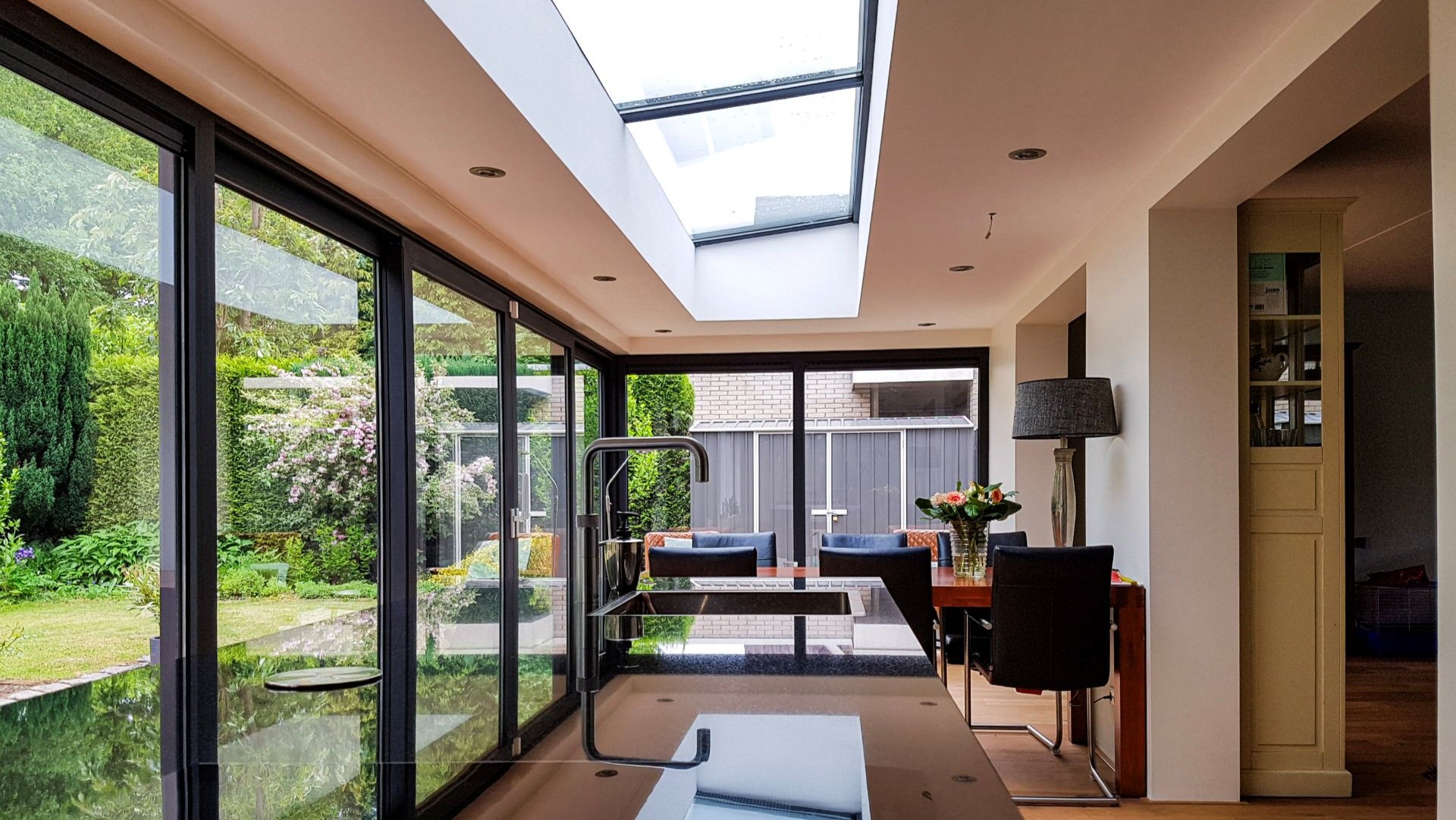 Design serre met grote glaspartijen, moderne keuken en stijlvolle eetkamer