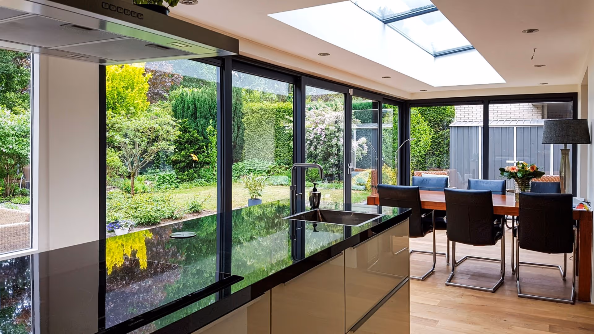 Moderne glazen serre met slanke aluminium kozijnen en luxe leefkeuken