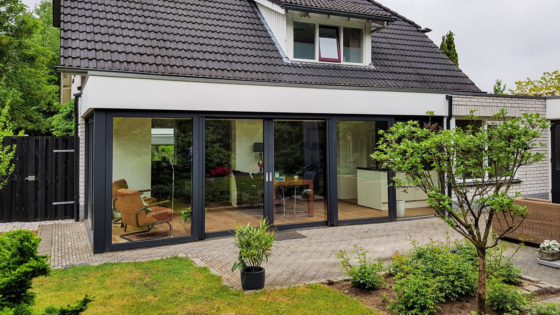 Moderne aluminium serre aanbouw met grote glazen schuifpuien en strak design