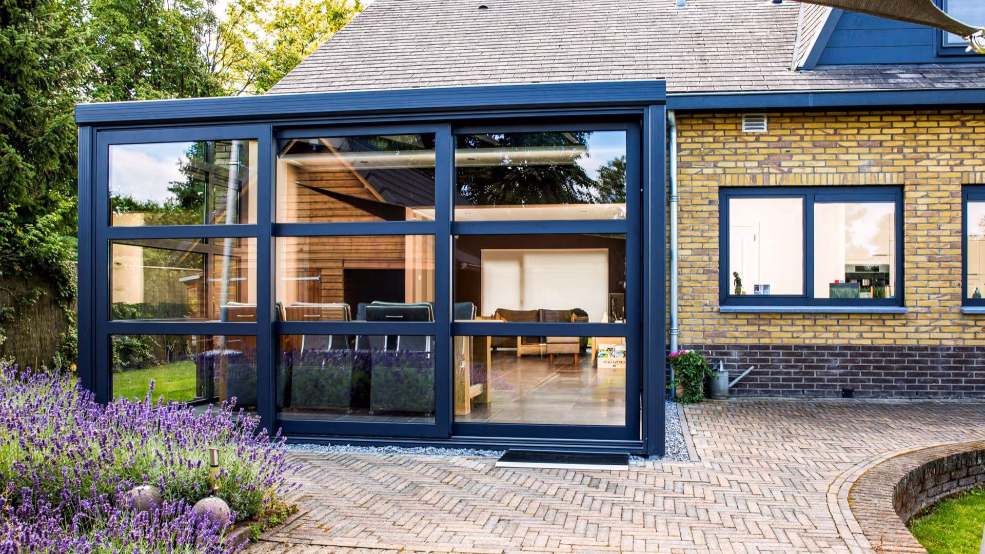 Strakke glazen tuinkamer met moderne eetruimte en luxe aluminium afwerking