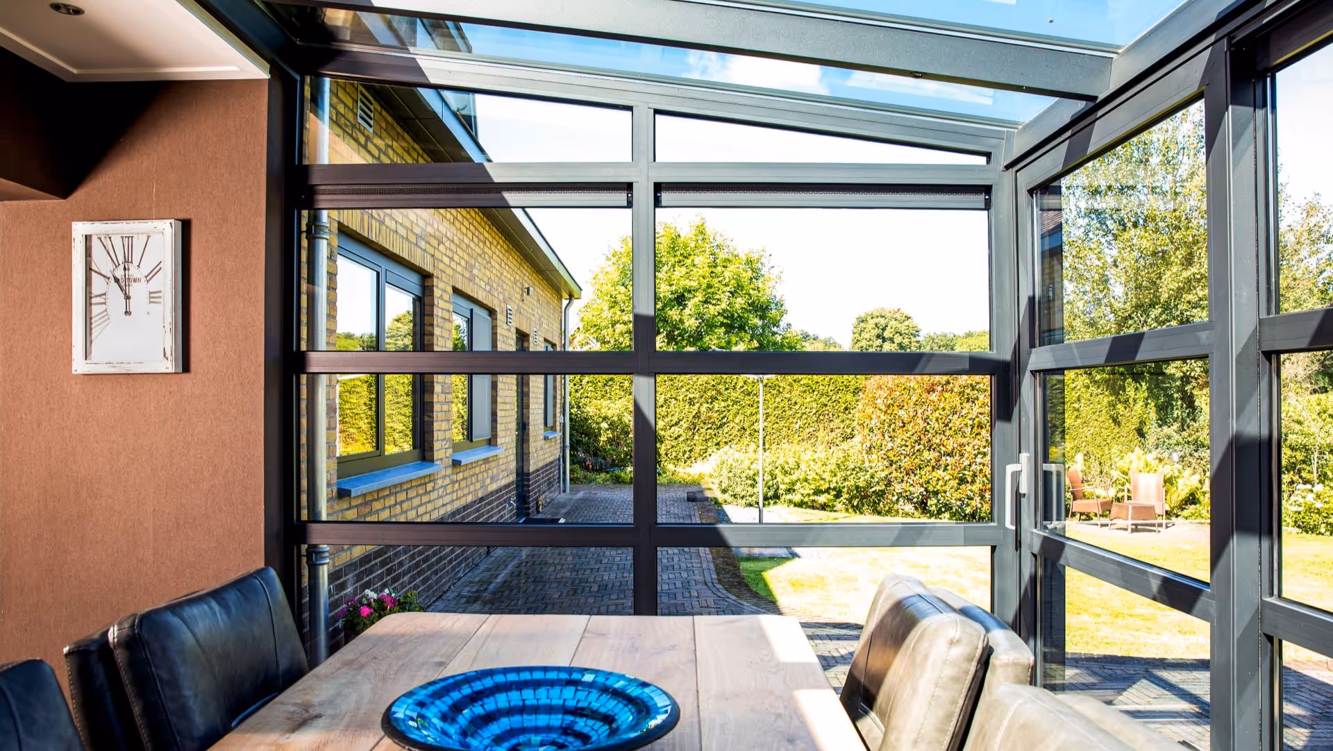 Moderne leefruimte met glazen serre, aluminium kozijnen en veel lichtinval