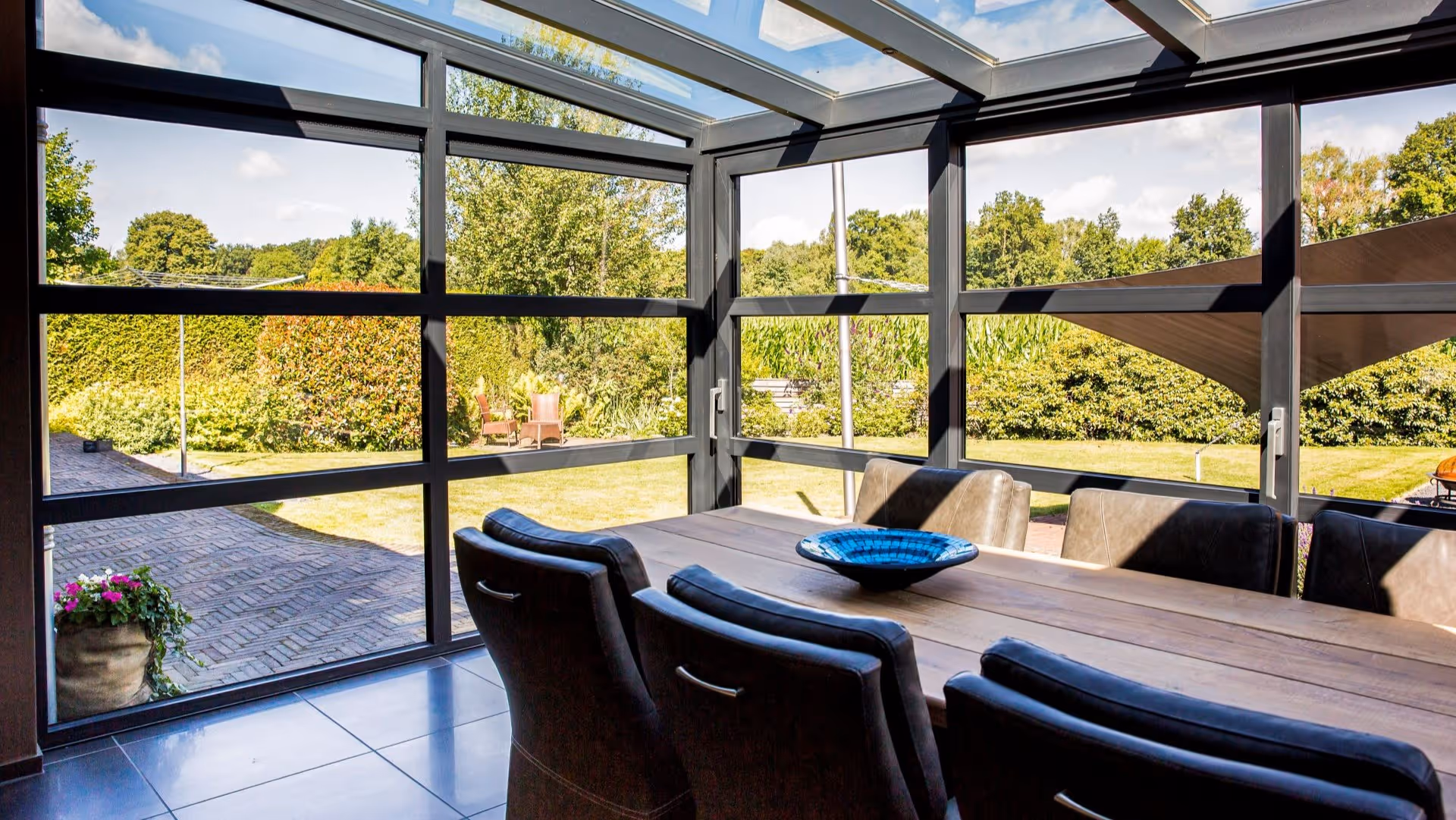 Luxe tuinkamer met glazen dak en panoramisch uitzicht op de groene tuin