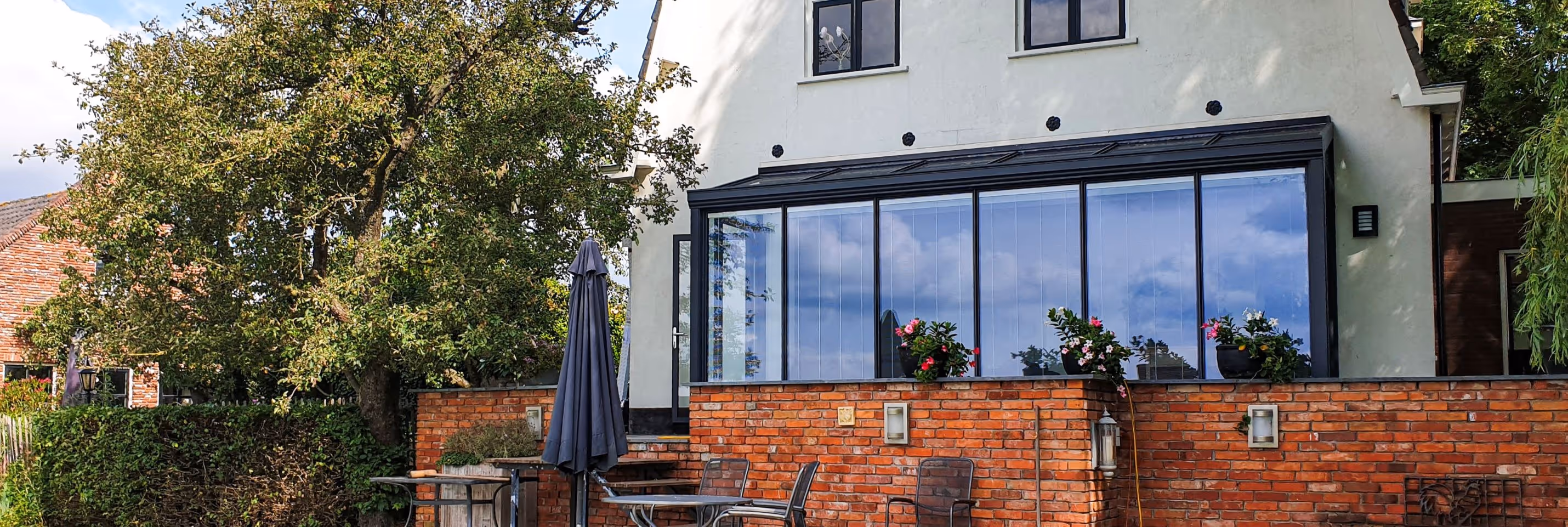 Steellook Serre - Moderne glazen serre aan woning met uitzicht op terras en landelijke tuin