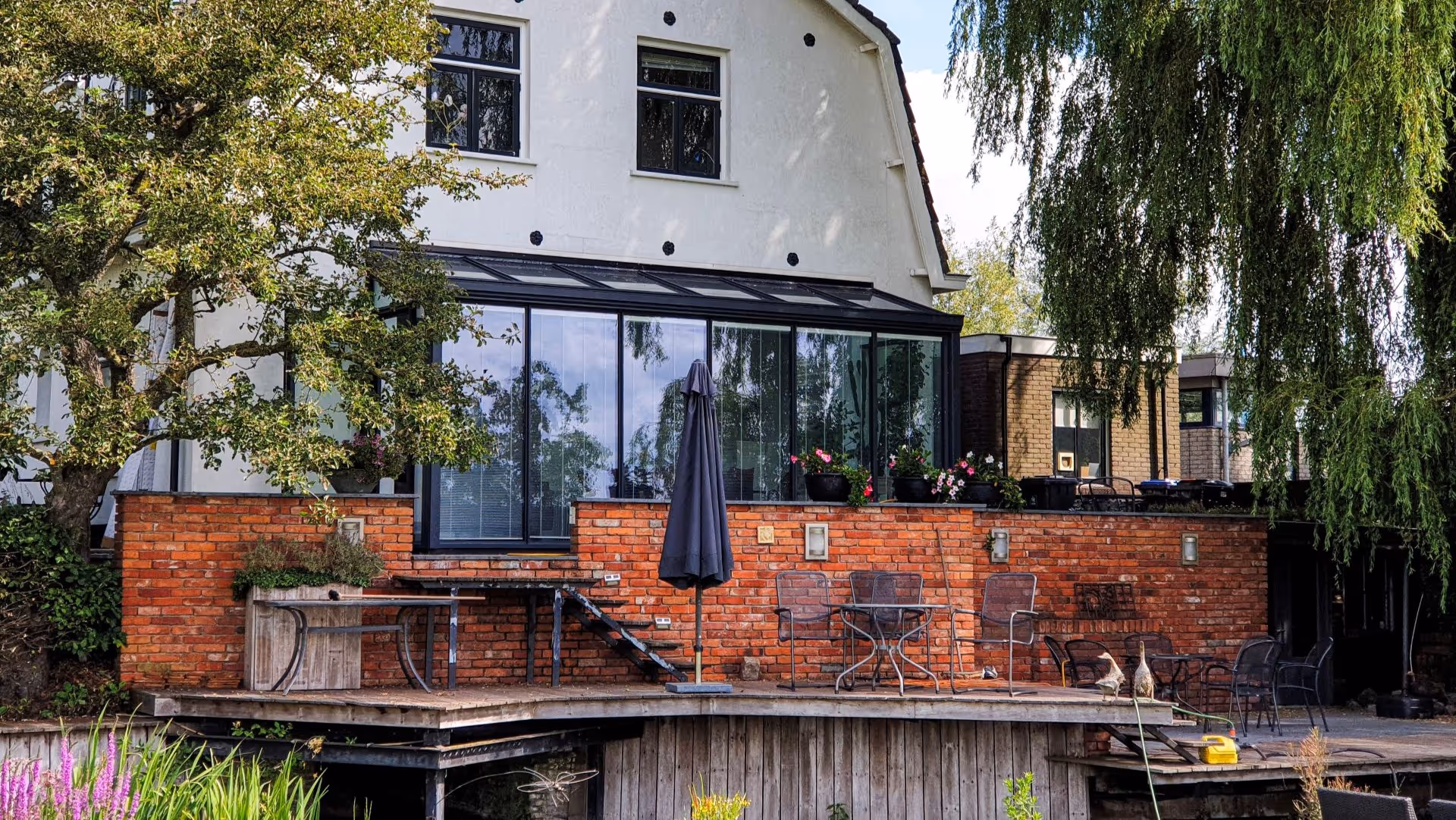 Strakke aluminium serre met glazen schuifwanden en moderne afwerking