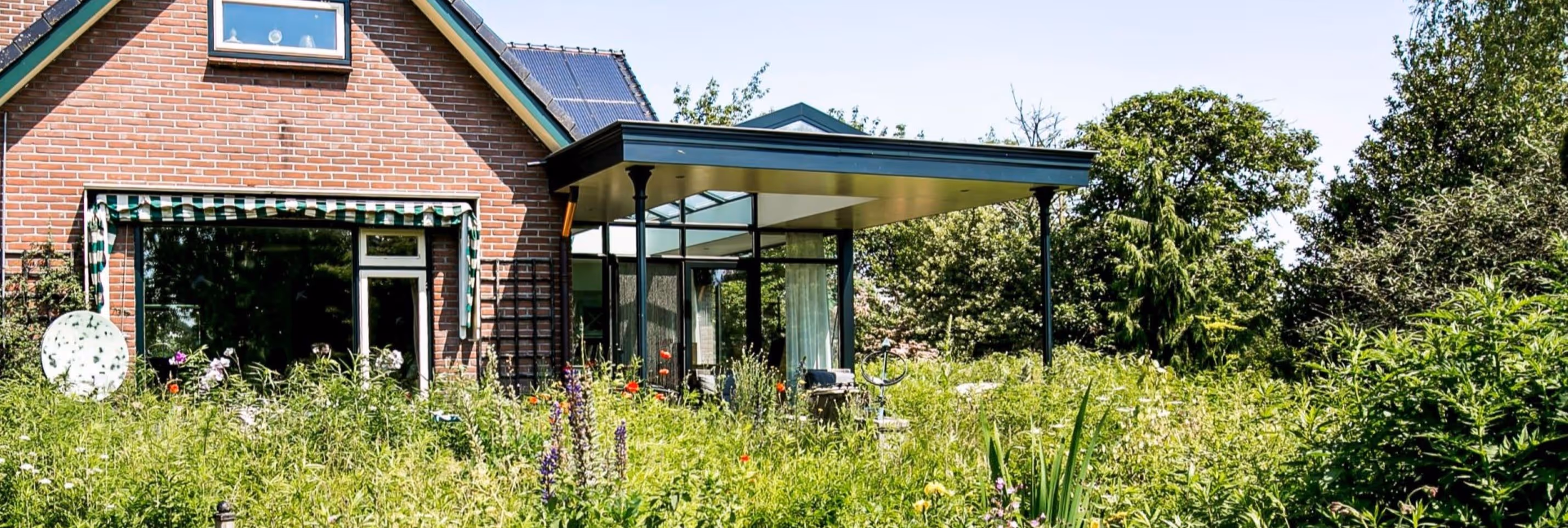 Steellook serre Emst - Moderne woning met glazen uitbouw en groene landelijke tuin