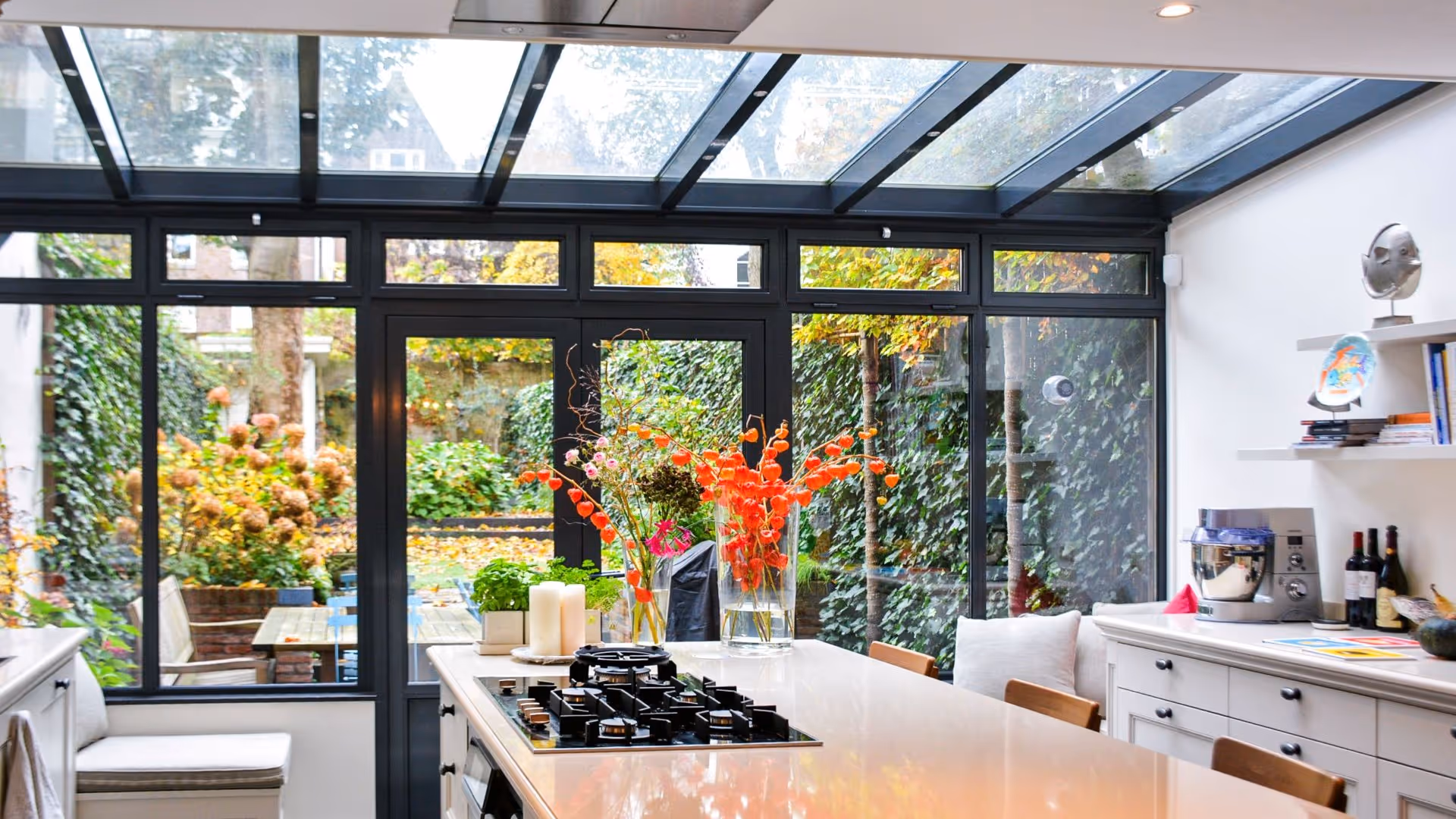 Luxe woonkeuken met glazen dak en uitzicht op groene stadstuin