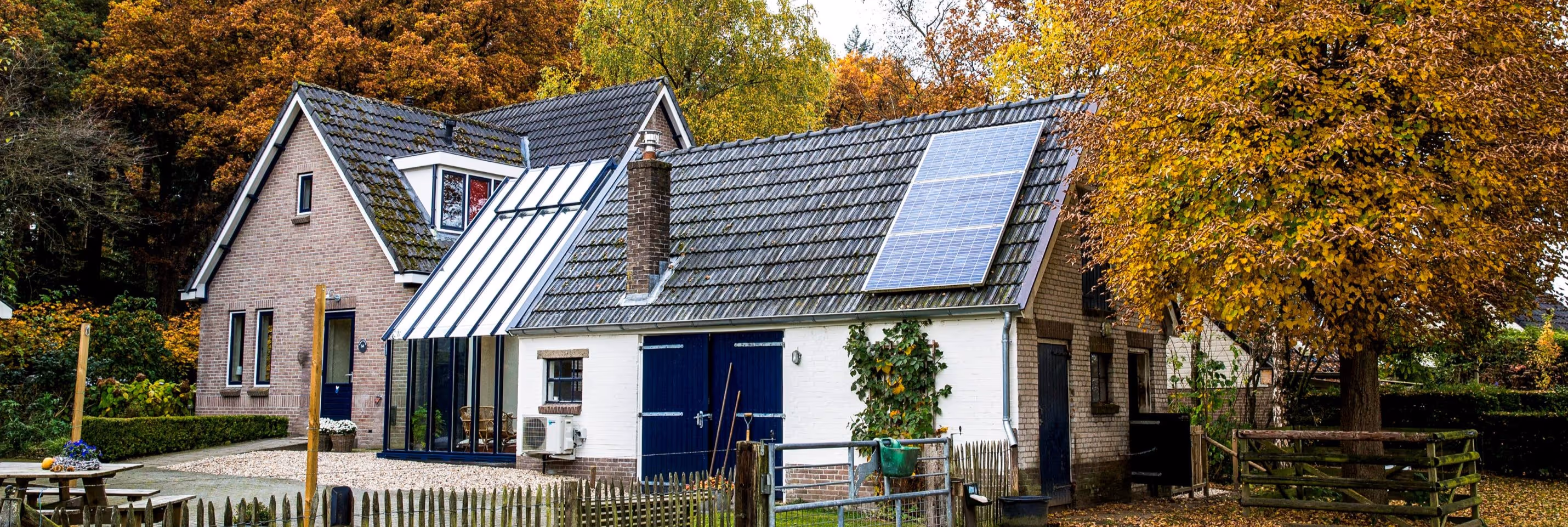 Steellook serre Apeldoorn - Moderne glazen tuinkamer met schuin dak naast landelijke schuurwoning