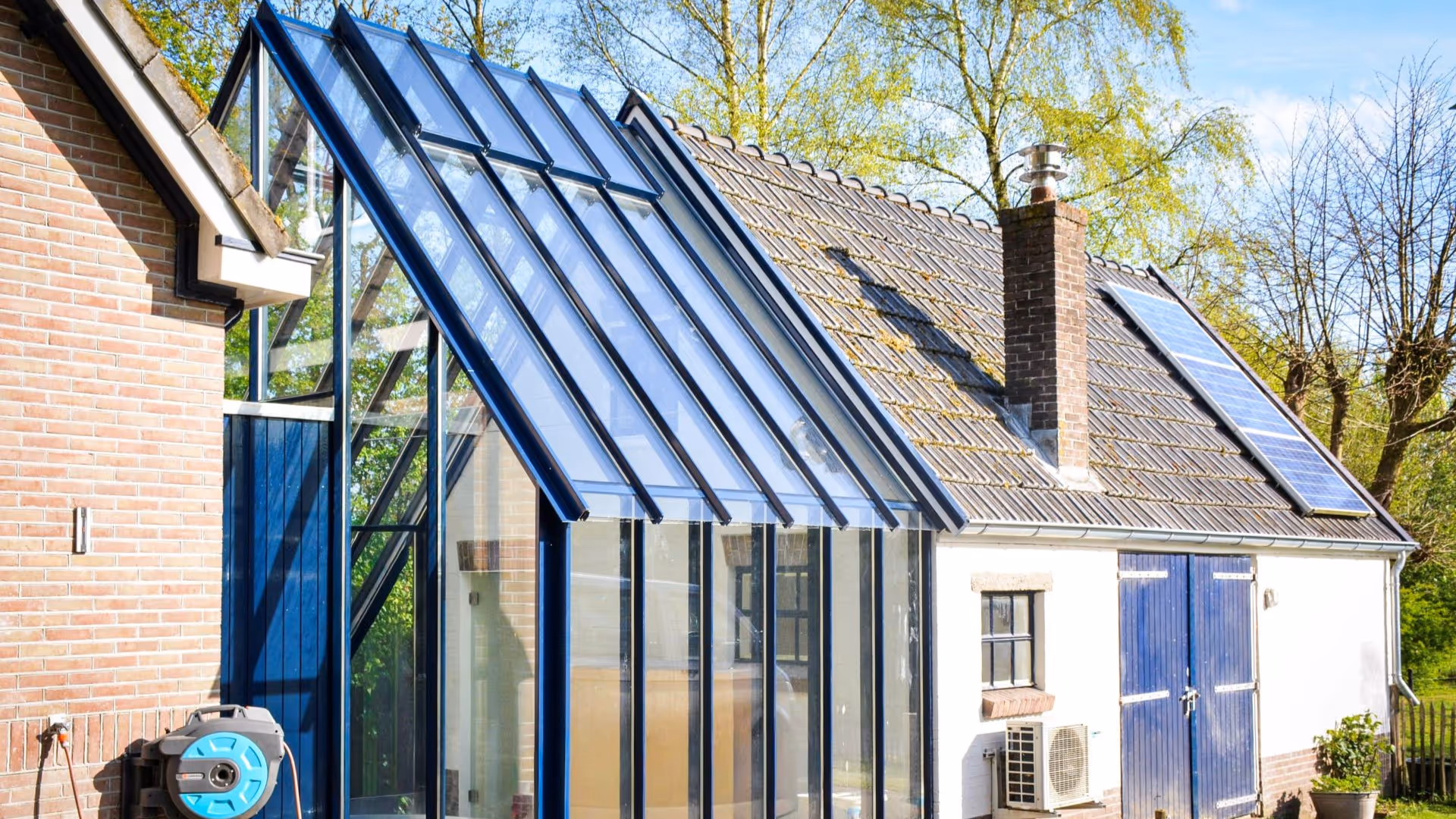 Luxe glazen uitbouw met zwart aluminium frame aan karakteristieke woning