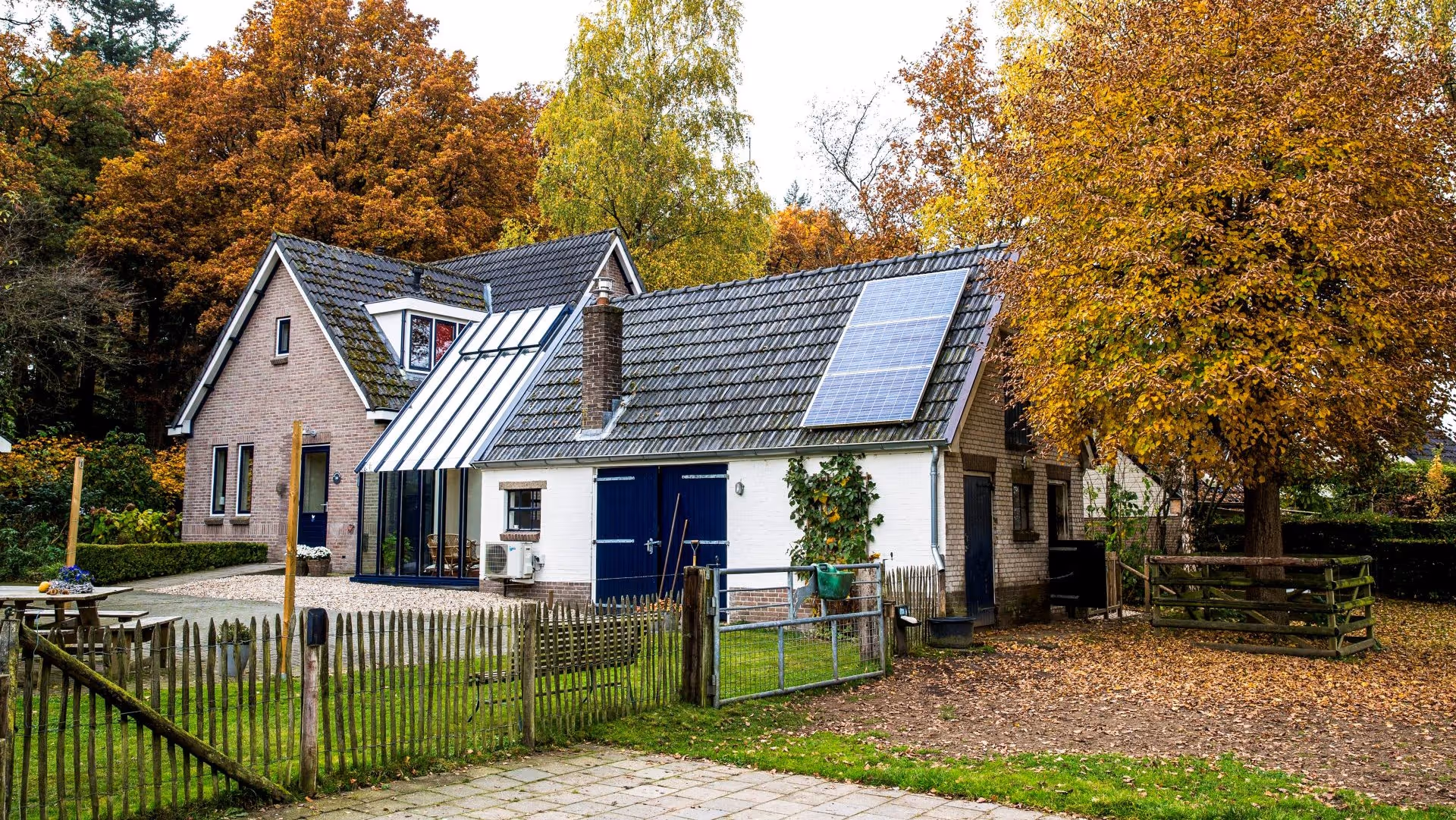 Landelijke woning met moderne glazen uitbreiding tussen bestaande gebouwen