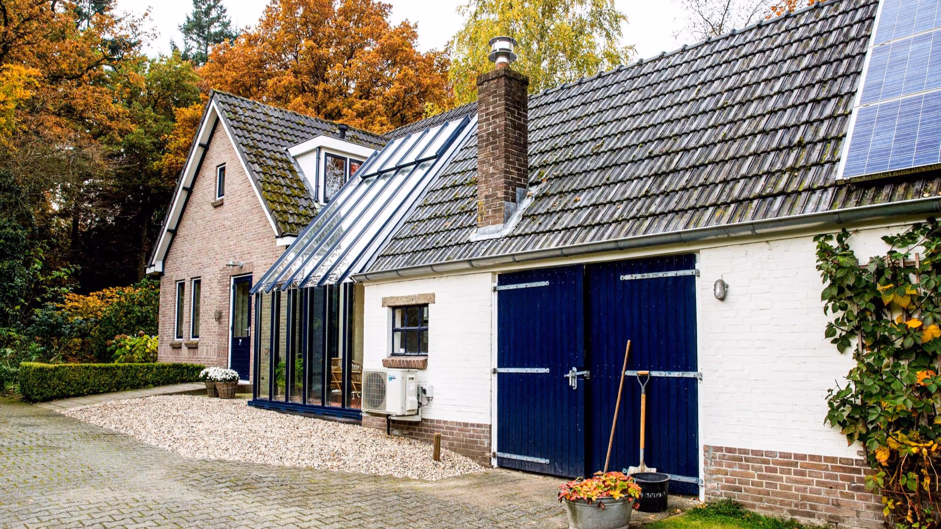 Landelijke woning met moderne glazen woonuitbreiding en zwart aluminium profiel