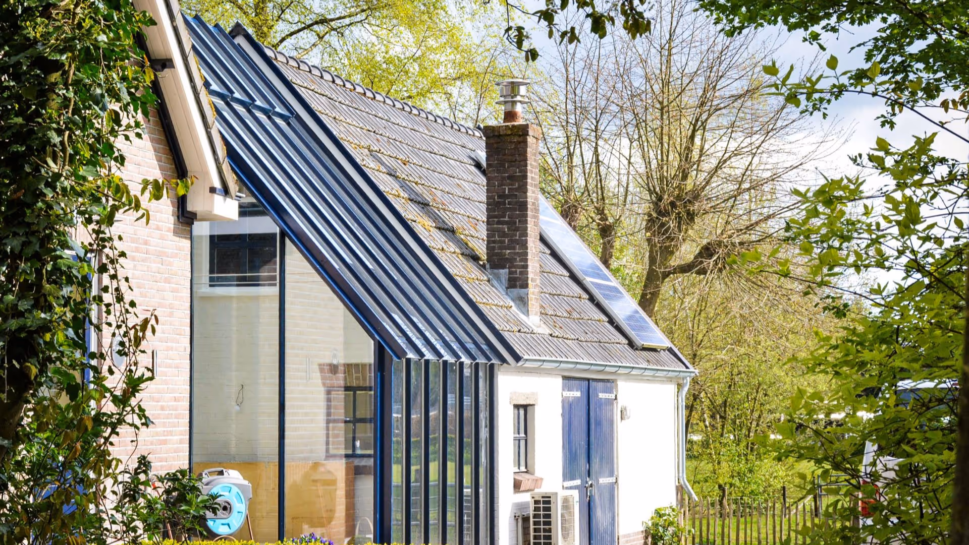Moderne glazen tuinkamer met schuin glazen dak en landelijke uitstraling